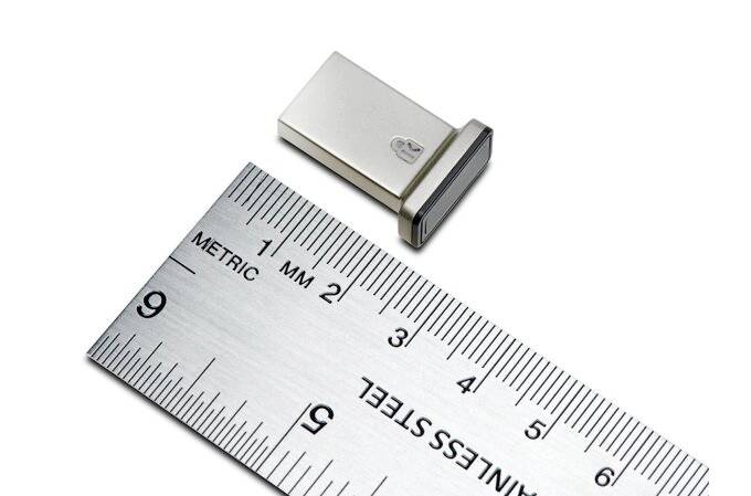 Ein USB-Stick liegt neben einem Lineal, das die Länge des Sticks anzeigt. Der Stick misst etwa 2 cm und hat ein metallisches Gehäuse.
