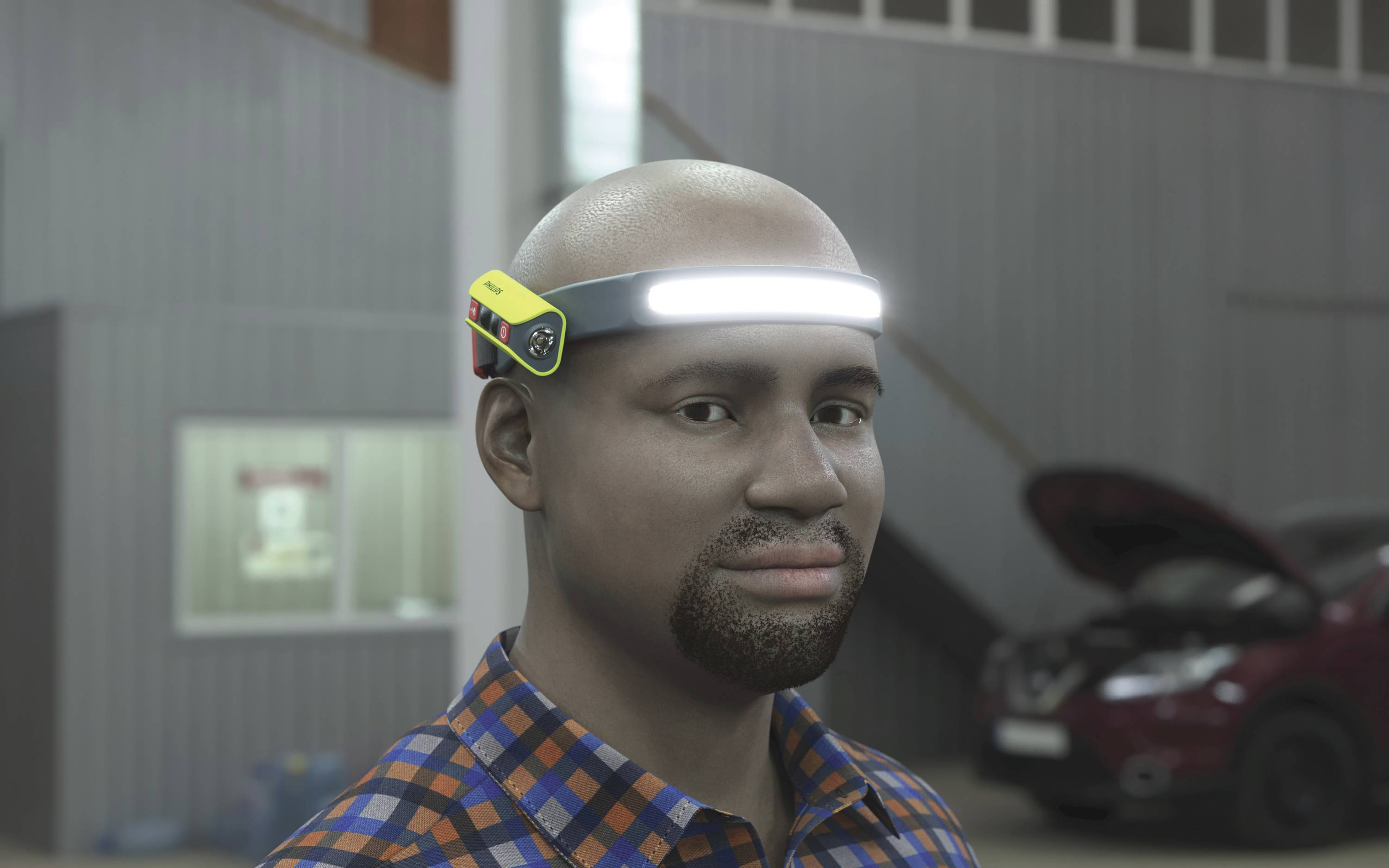 Ein lächelnder Mann trägt ein LED-Stirnband in einer Werkstatt. Im Hintergrund steht ein Auto mit geöffneter Motorhaube.