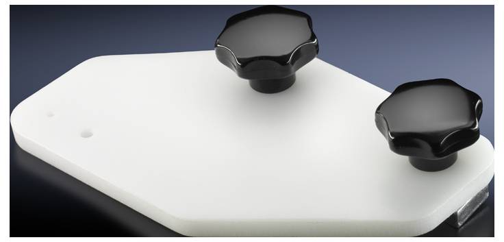 Weiße polygonale Platte mit zwei schwarzen Knöpfen auf dunkelblauem Hintergrund.