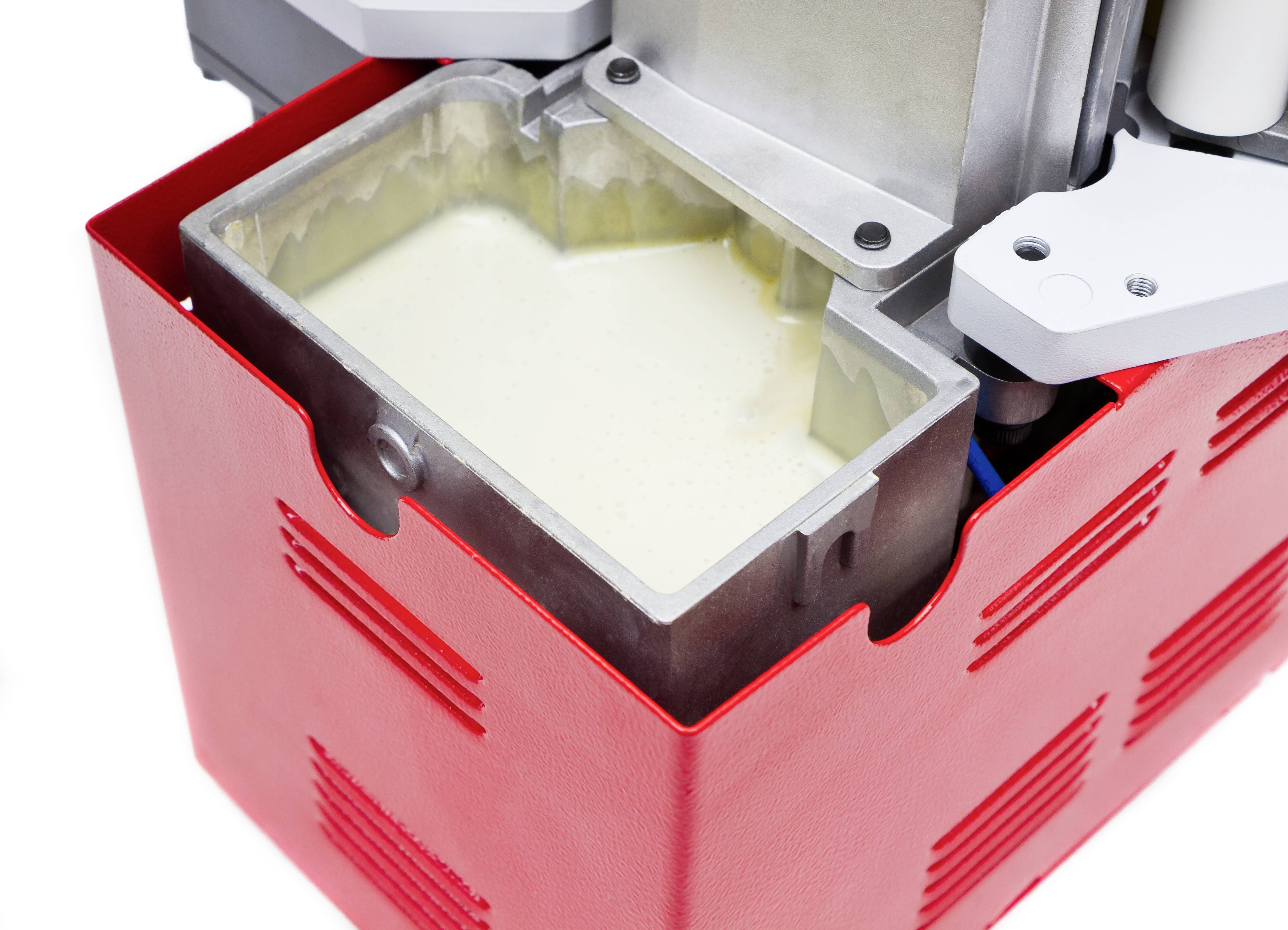 Ein roter Eiscreme-Maker mit geöffneter Schüssel, die mit fertigem Vanilleeis gefüllt ist.