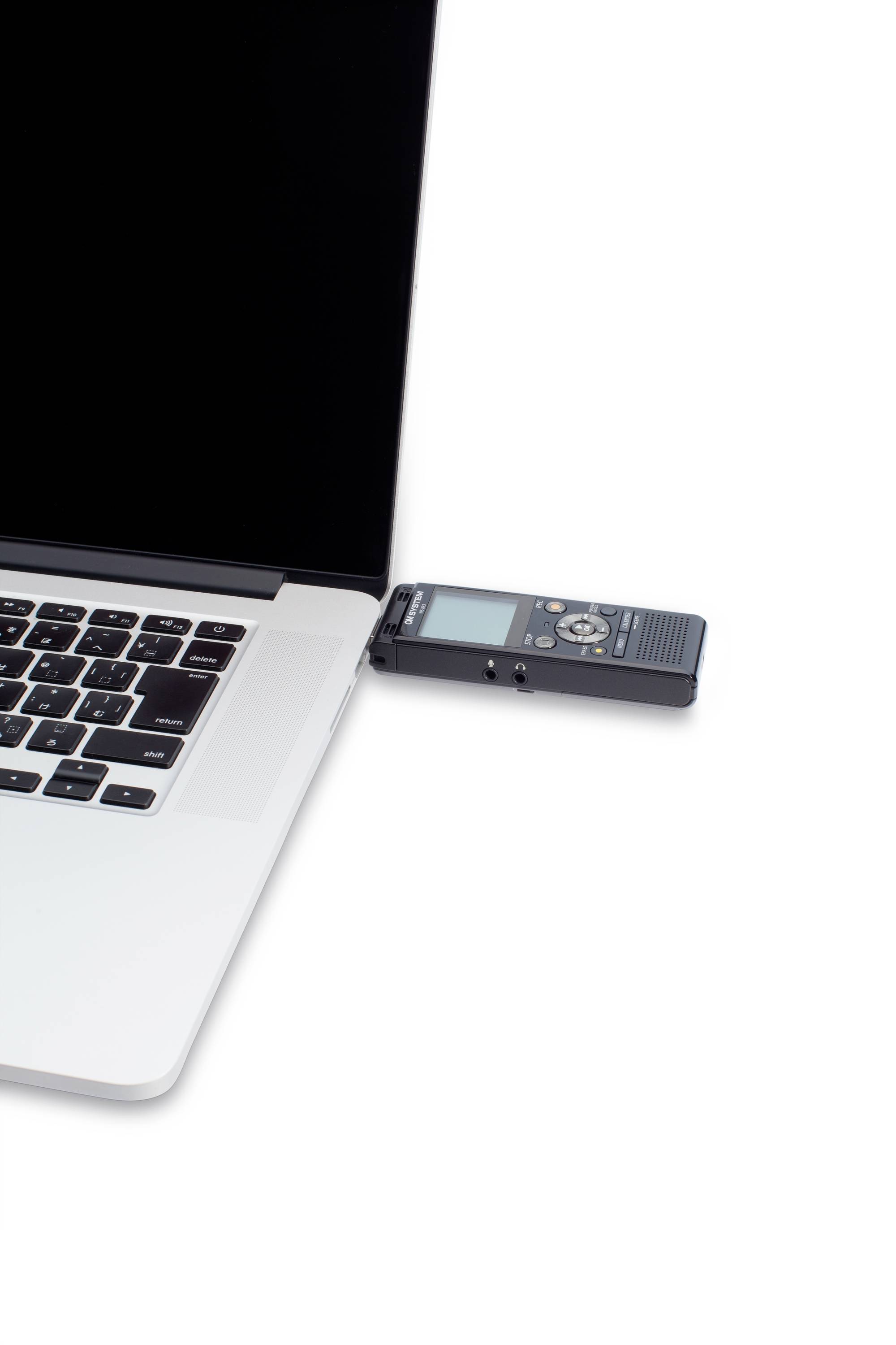 Ein Laptop mit einem angesteckten digitalen Audiorekorder. Der Rekorder ist über USB verbunden und neben dem Touchpad platziert.