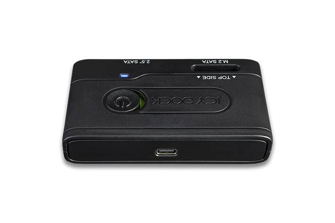 Ein schwarzes, rechteckiges elektronisches Gerät mit Anschlüssen auf der Vorderseite und einer Taste auf der Oberseite.