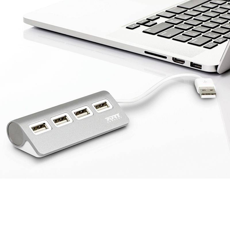 Ein USB-Hub mit drei USB-Anschlüssen ist an einen Laptop angeschlossen, der auf einem weißen Tisch steht.