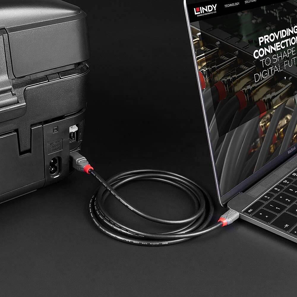 Laptop mit verbundenem HDMI-Kabel, das an einen Drucker angeschlossen ist. Der Bildschirm zeigt das Bild einer digitalen Leitung.