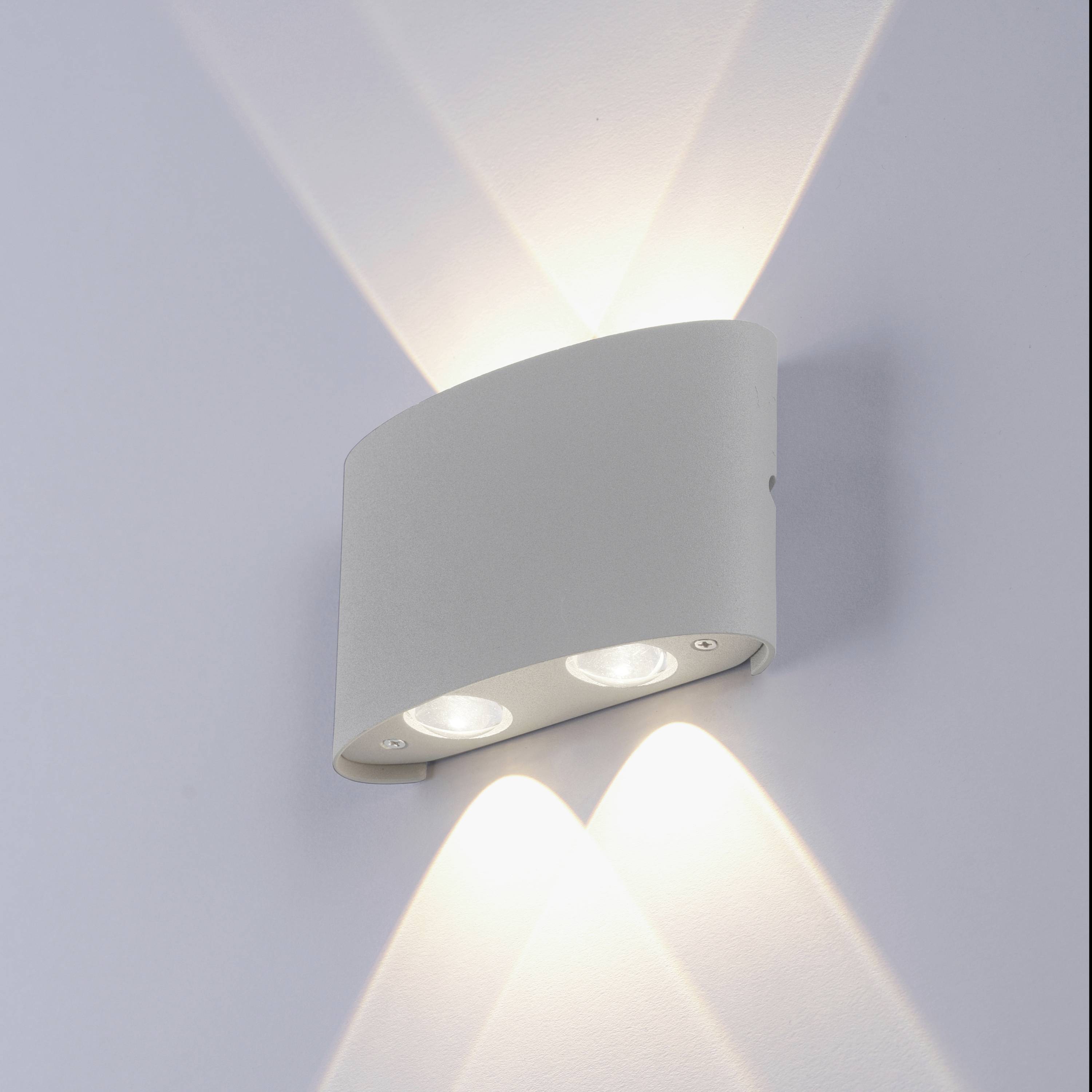 Wandleuchte mit zwei Lichtstrahlen, die nach oben und unten scheinen. Modernes, schlichtes Design, montiert auf einer weißen Wand.