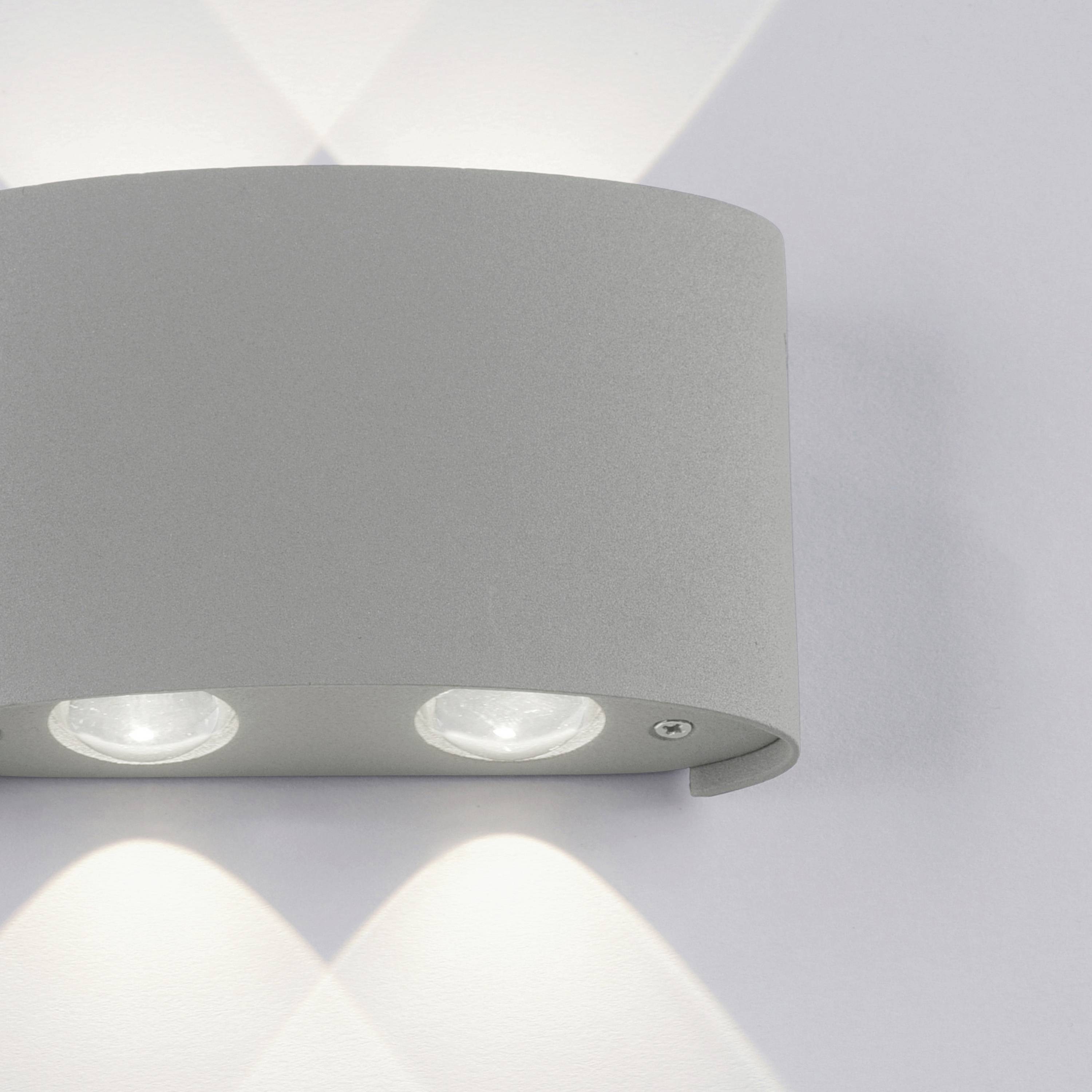 Wandleuchte mit gebogener Front und zwei Lichtquellen. Licht strahlt nach oben und unten und schafft ein sanftes Muster auf der Wand.