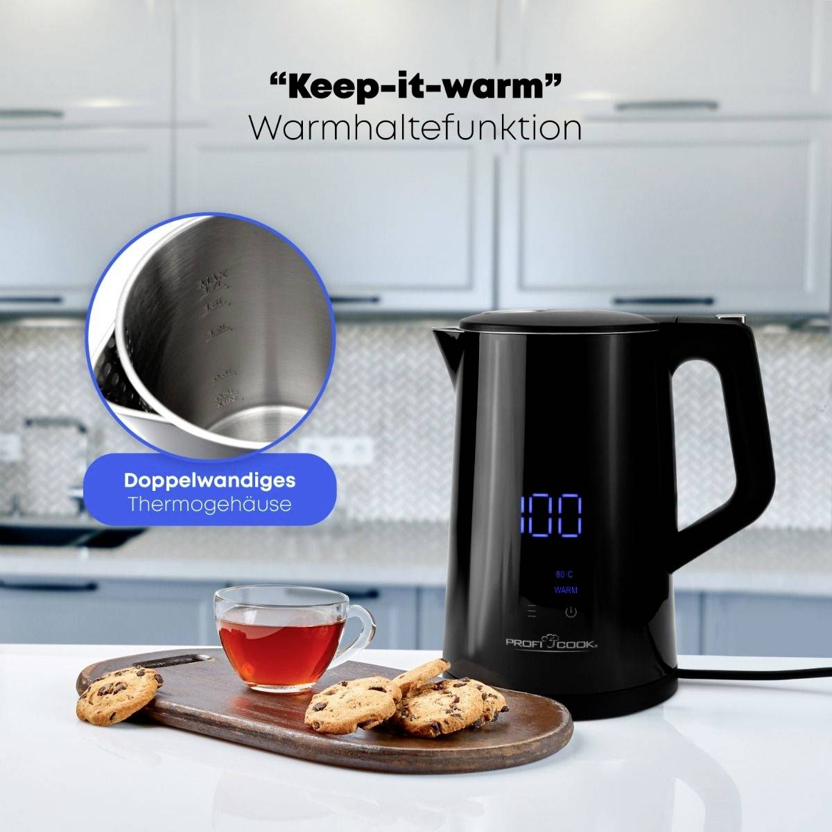 Ein Wasserkocher mit digitaler Anzeige steht auf einer Küchenarbeitsplatte. Daneben sind eine Tasse Tee und Kekse auf einem Holzbrett.