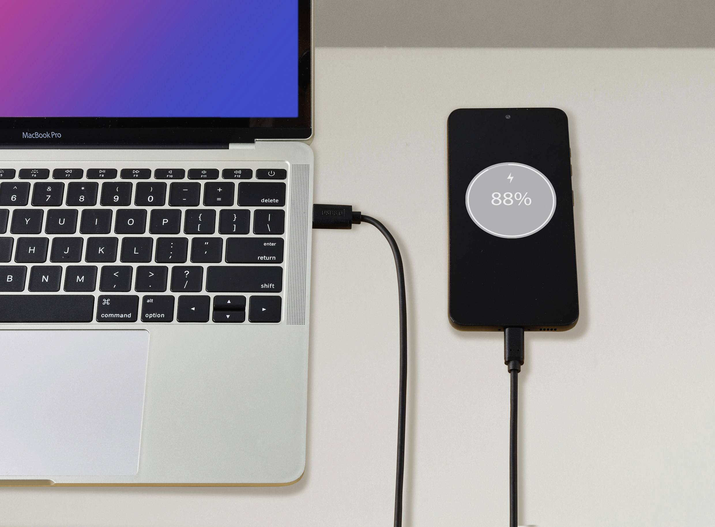 Laptop und Smartphone sind verbunden. Das Smartphone wird geladen und zeigt 88% Akkuladestand an.