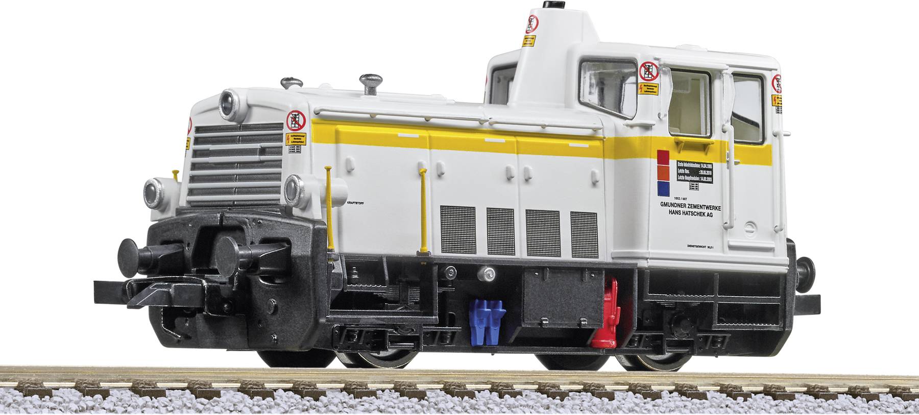 Ein weißer und gelber Modell-Eisenbahnlok mit detaillierten Elementen, auf einem Gleis ausgestellt.