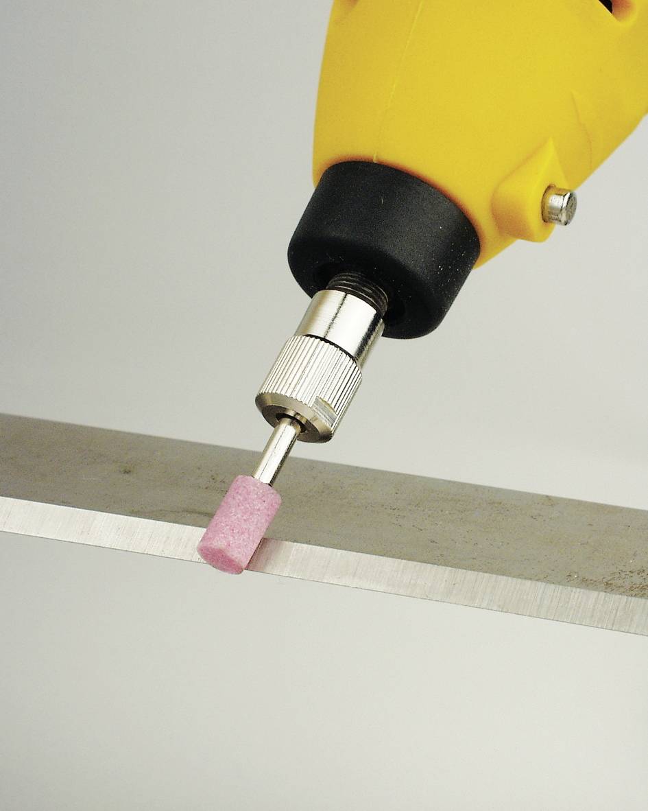 Gelber Bohrer mit rosa Schleifaufsatz bearbeitet eine Metallkante.