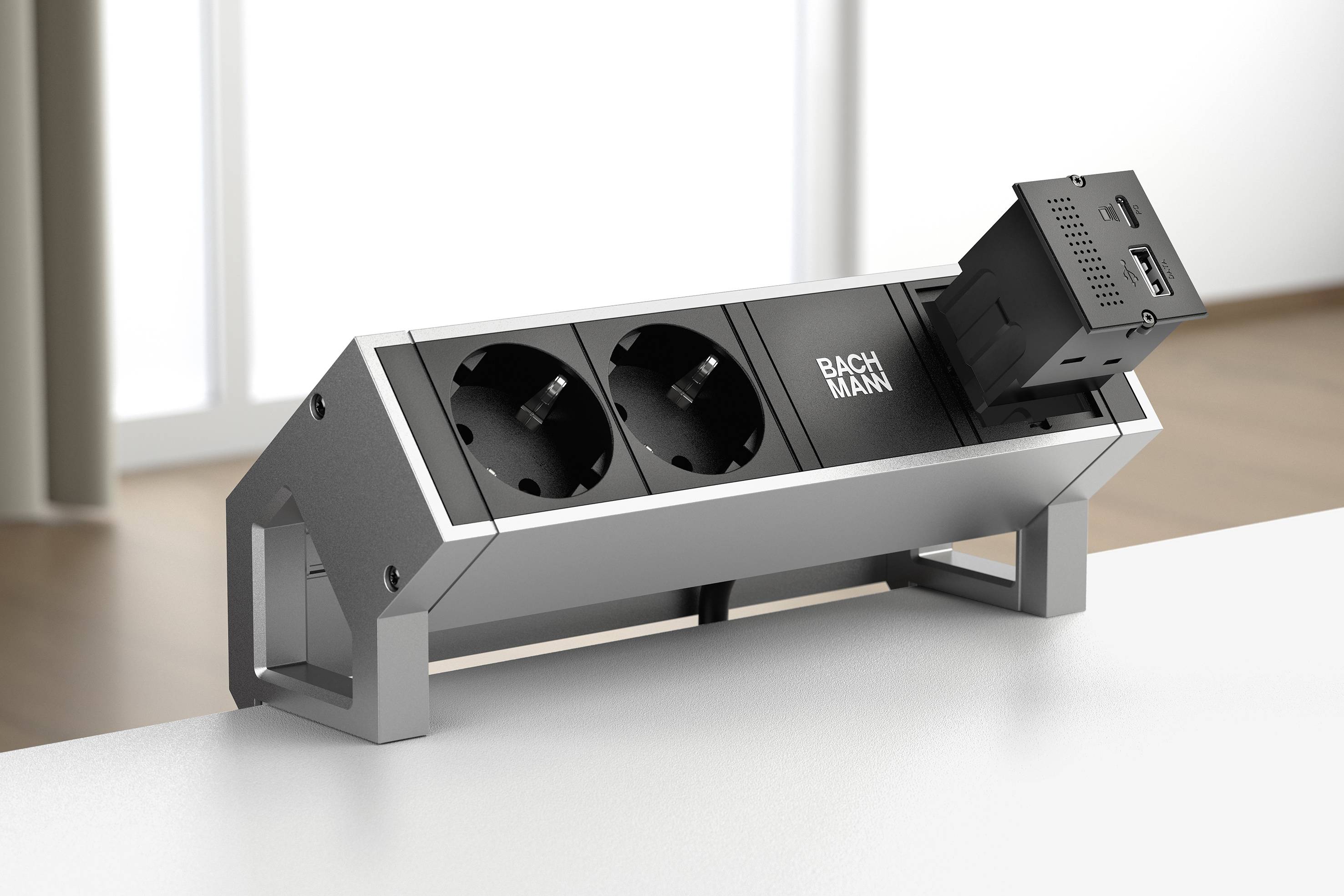 Stromverteiler auf Tisch mit zwei Steckdosen und einem HDMI-Anschlussmodul. Helle, moderne Umgebung im Hintergrund.