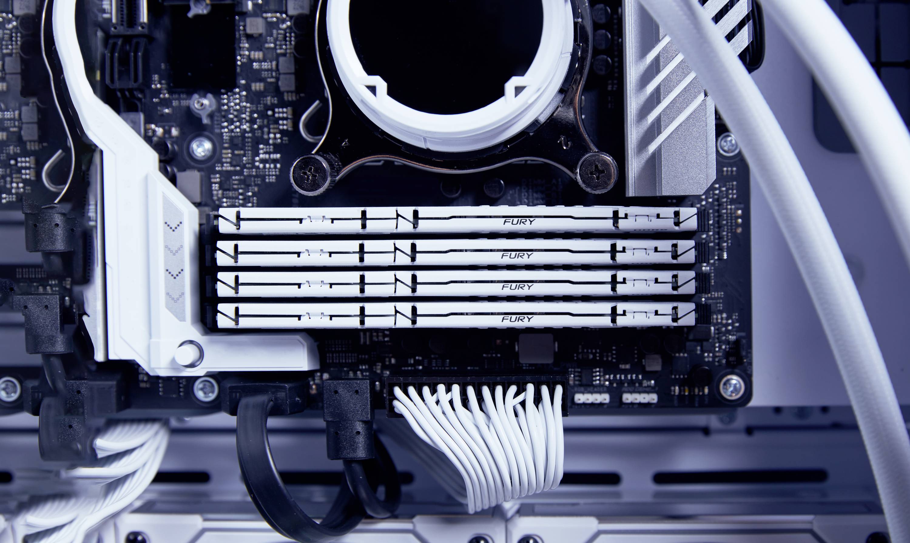 Nahaufnahme eines Computer-Mainboards mit installierten RAM-Modulen und Kabeln; zeigt technische Details und Anordnung der Komponenten.