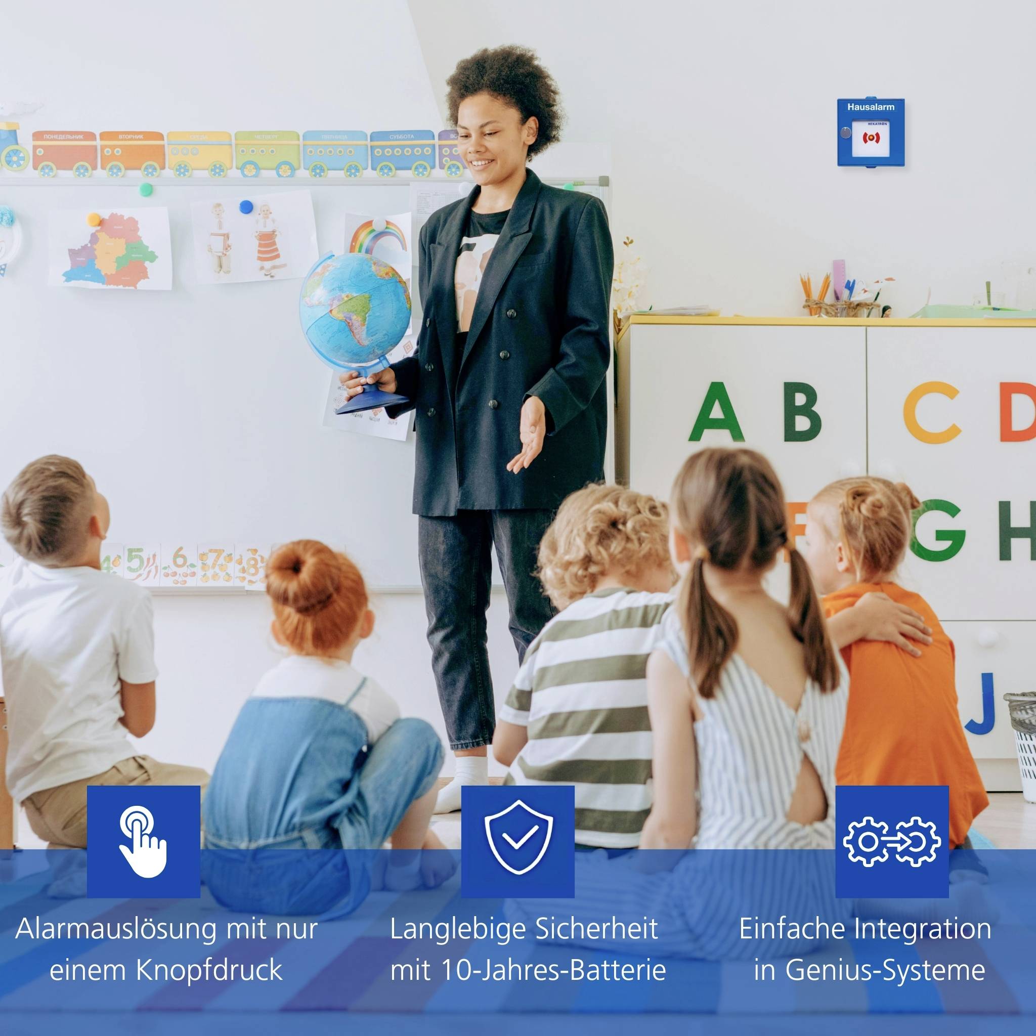 Ein Lehrer zeigt sitzenden Kindern einen Globus im Klassenzimmer. Banner darunter heben Merkmale hervor: ‚Alarmauslösung', ‚10-Jahres-Batterie', ‚Systemintegration'.