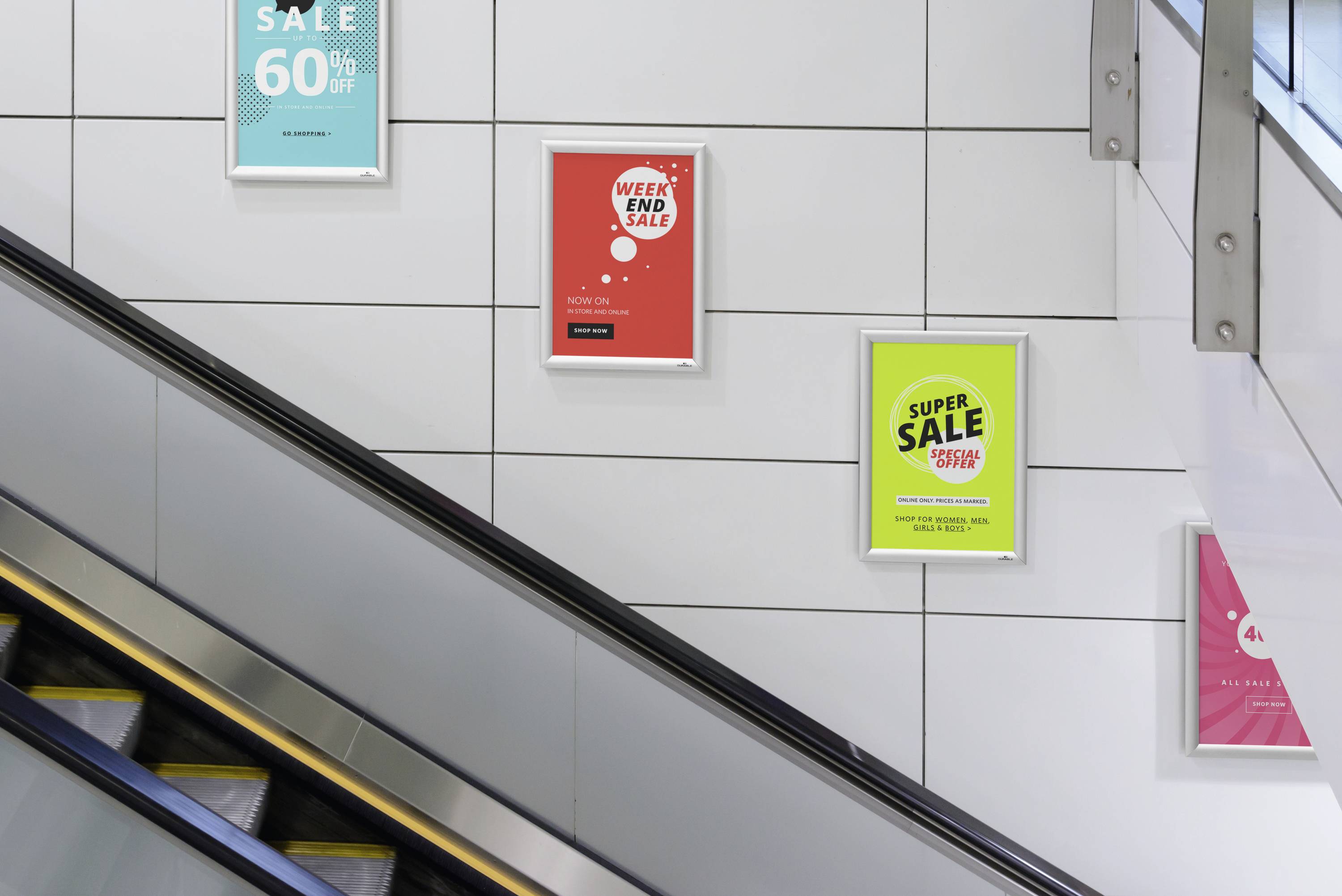 Vier Werbeplakate hängen an einer Wand entlang einer Rolltreppe: 'SALE 60%', 'WEEKEND SALE 20%', 'SUPER SALE 50%', '4-FACH'.