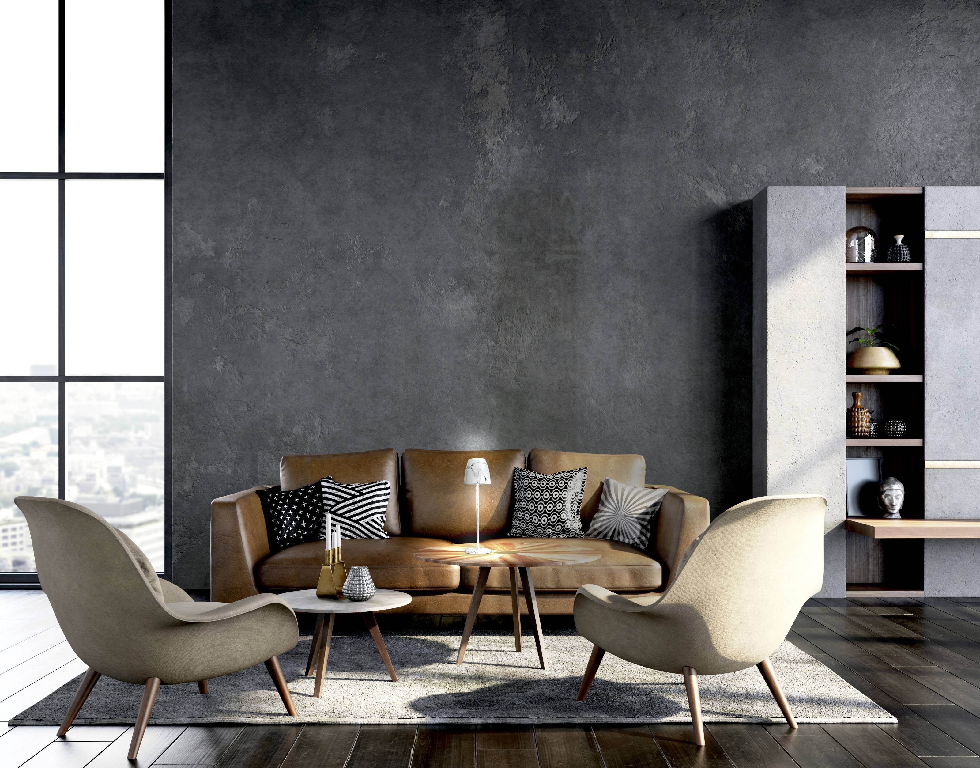 Ein modernes Wohnzimmer mit braunen Sofa, zwei Sesseln und einem kleinen Tisch. Regal im Hintergrund, große Fenster links.