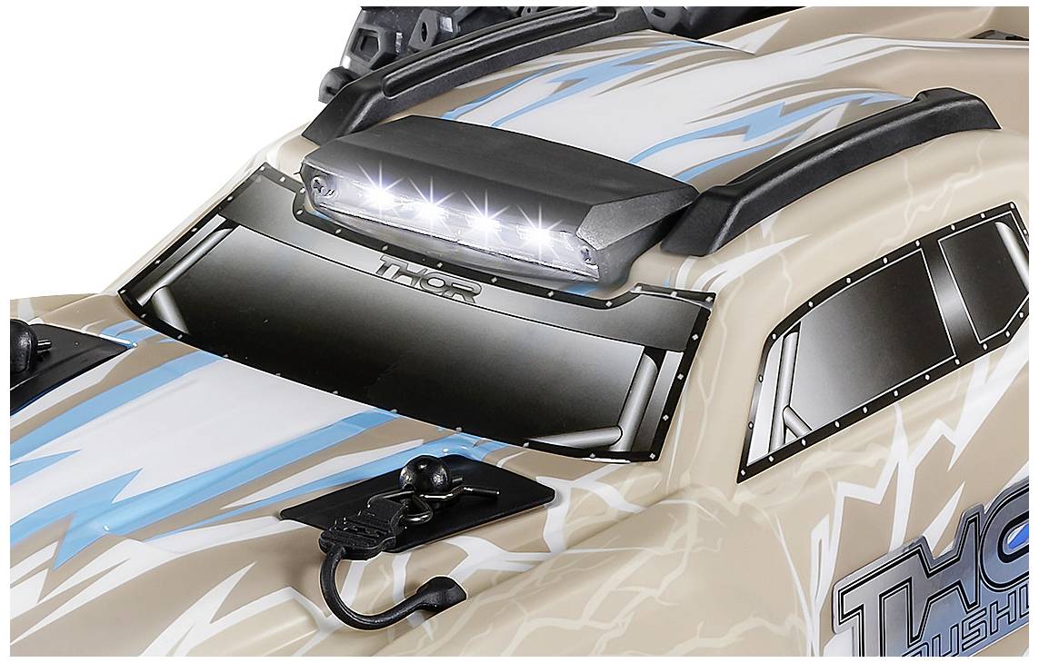 Nahaufnahme eines Spielzeugautos mit blitzendem LED-Licht auf dem Dach, beigefarbene Karosserie und blauen Blitzdesigns.