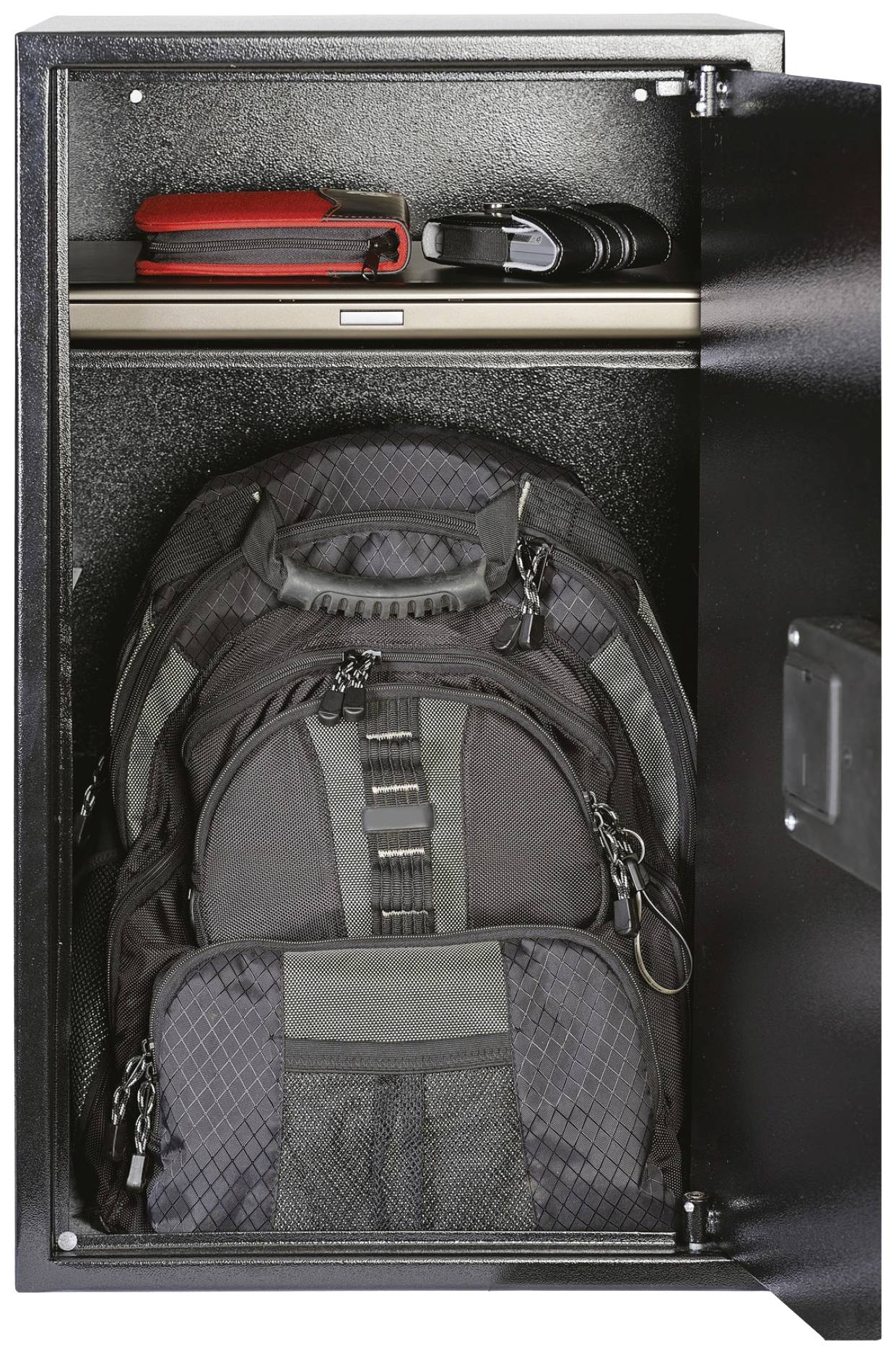 Ein offener Schrank mit einem großen schwarzen Rucksack unten, einem Laptop und einer Tasche auf dem oberen Regal.