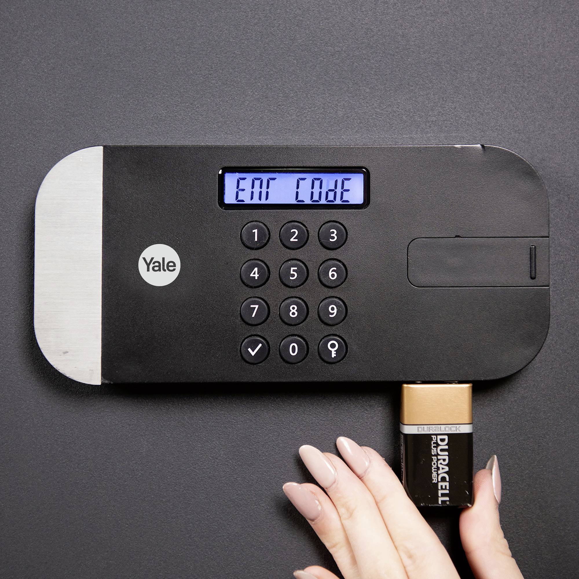 Elektronisches Türschloss mit Zahlentastatur und Display, das 'ENT Code' anzeigt. Eine Hand hält eine Batterie am Schloss.