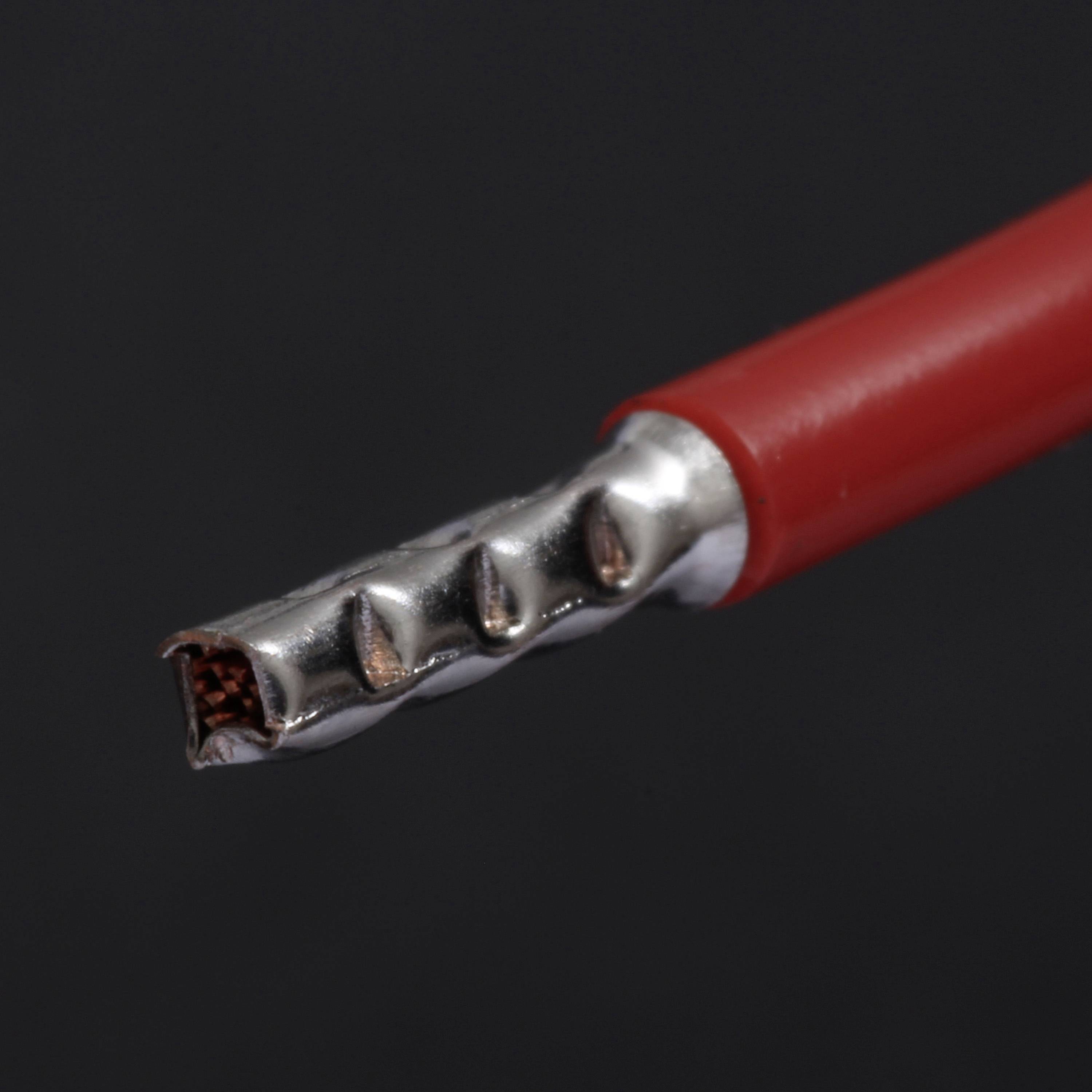 Nahaufnahme eines roten elektrischen Kabels mit freiliegendem, metallischem Leiter am Ende. Der freiliegende Leiter hat ein gezacktes Aussehen.