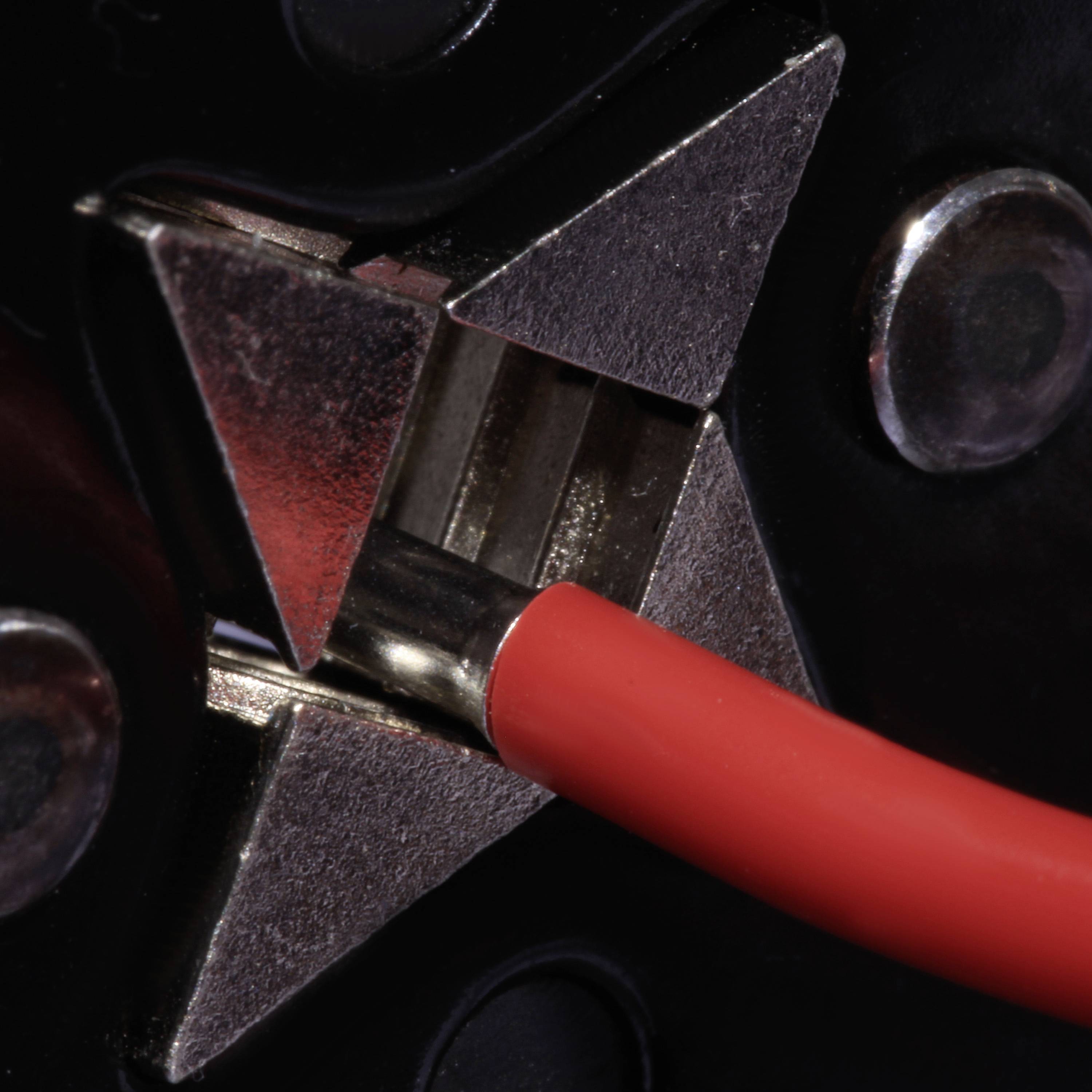 Rotes Kabel in einer metallischen Halterung vor schwarzem Hintergrund, symbolisiert Technik oder Elektronik.