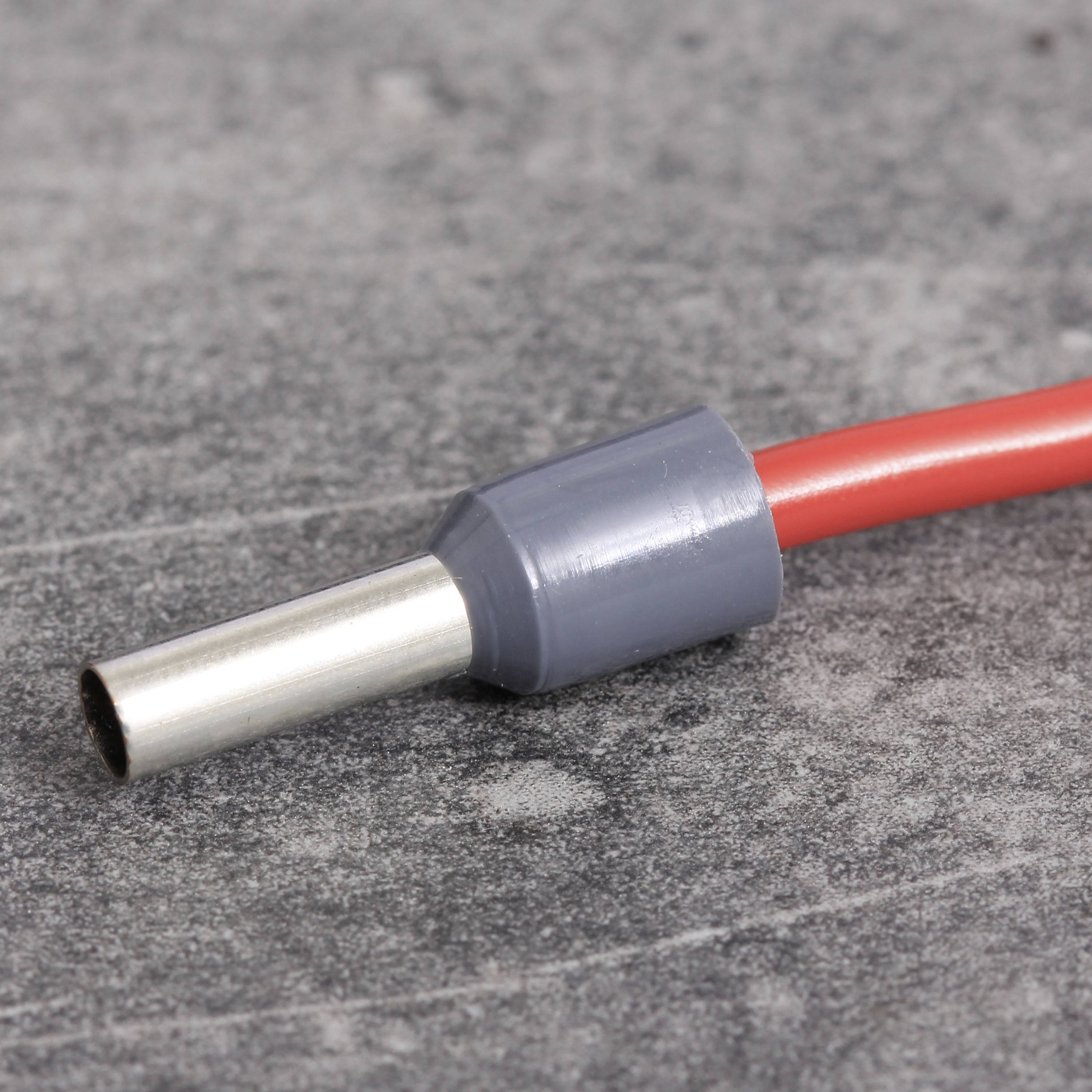 Ein grauer Kabelanschluss mit rotem Kabel auf grauem Hintergrund.