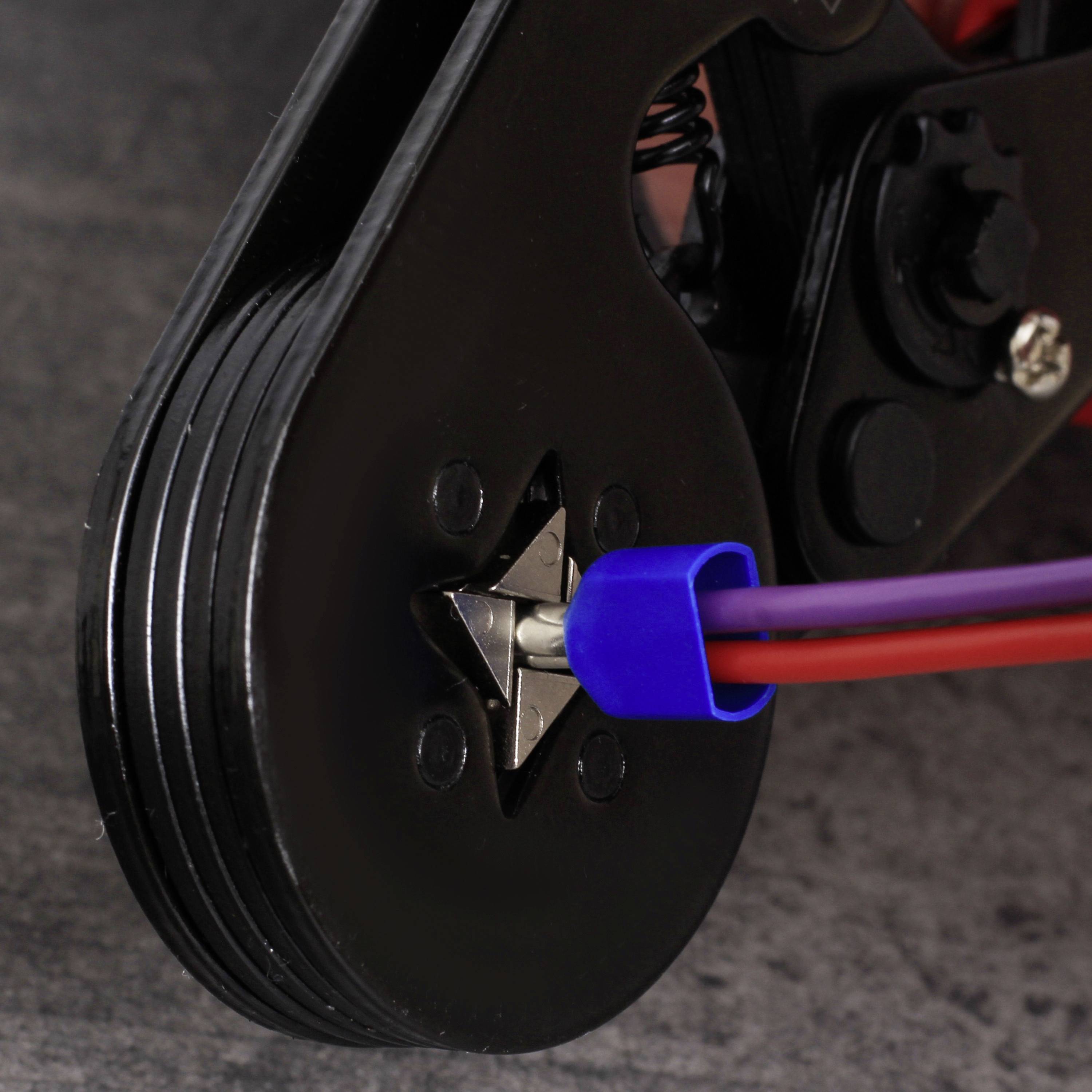 Ein Detailbild eines schwarzen Sternschrauben-Rads mit blauem Kabel, das um eine Rolle gewickelt ist.