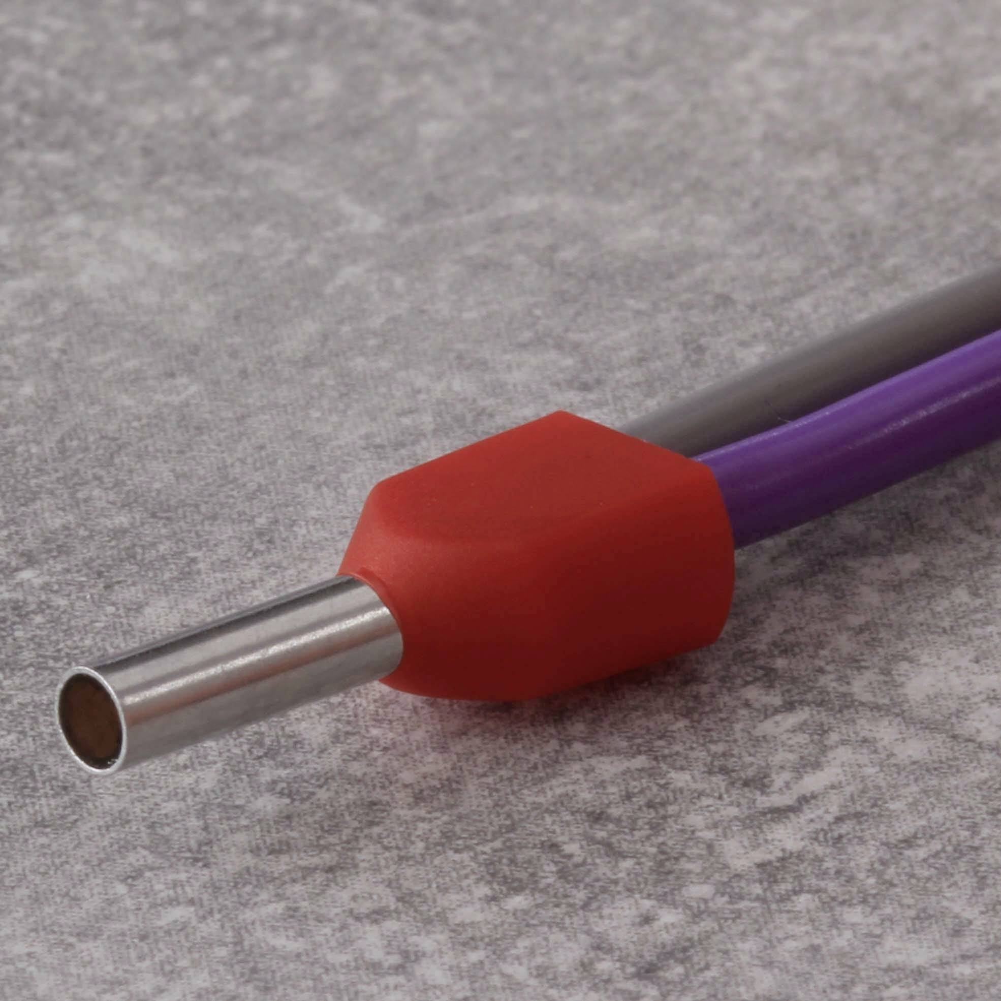 Metallrohr und biegbarer lila Kunststoffschlauch mit rotem Schutzüberzug, auf grauer Oberfläche liegend.