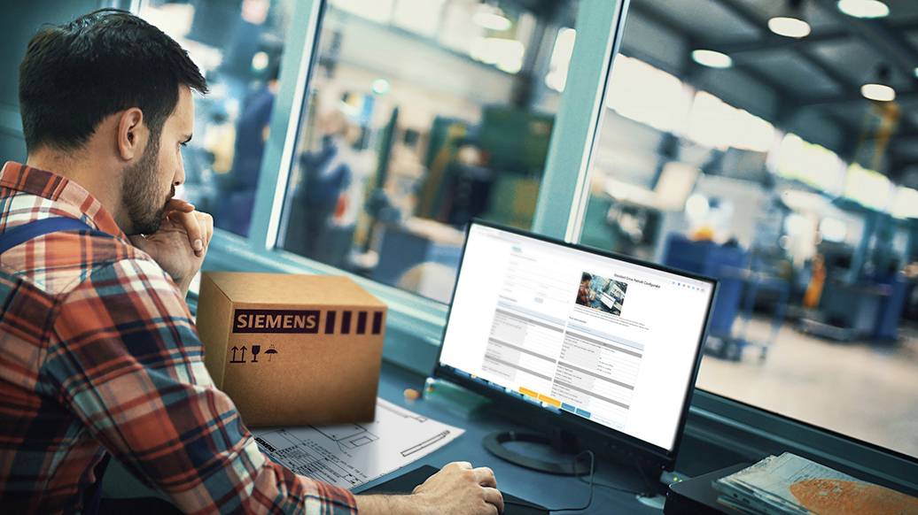 Ein Mann in kariertem Hemd arbeitet am Computer in einer industriellen Umgebung. Ein Siemens-Paket liegt auf seinem Tisch.