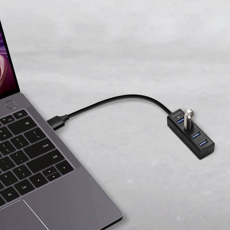 Ein Laptop mit einem verbundenen USB-Hub, an den mehrere Geräte angeschlossen werden können.