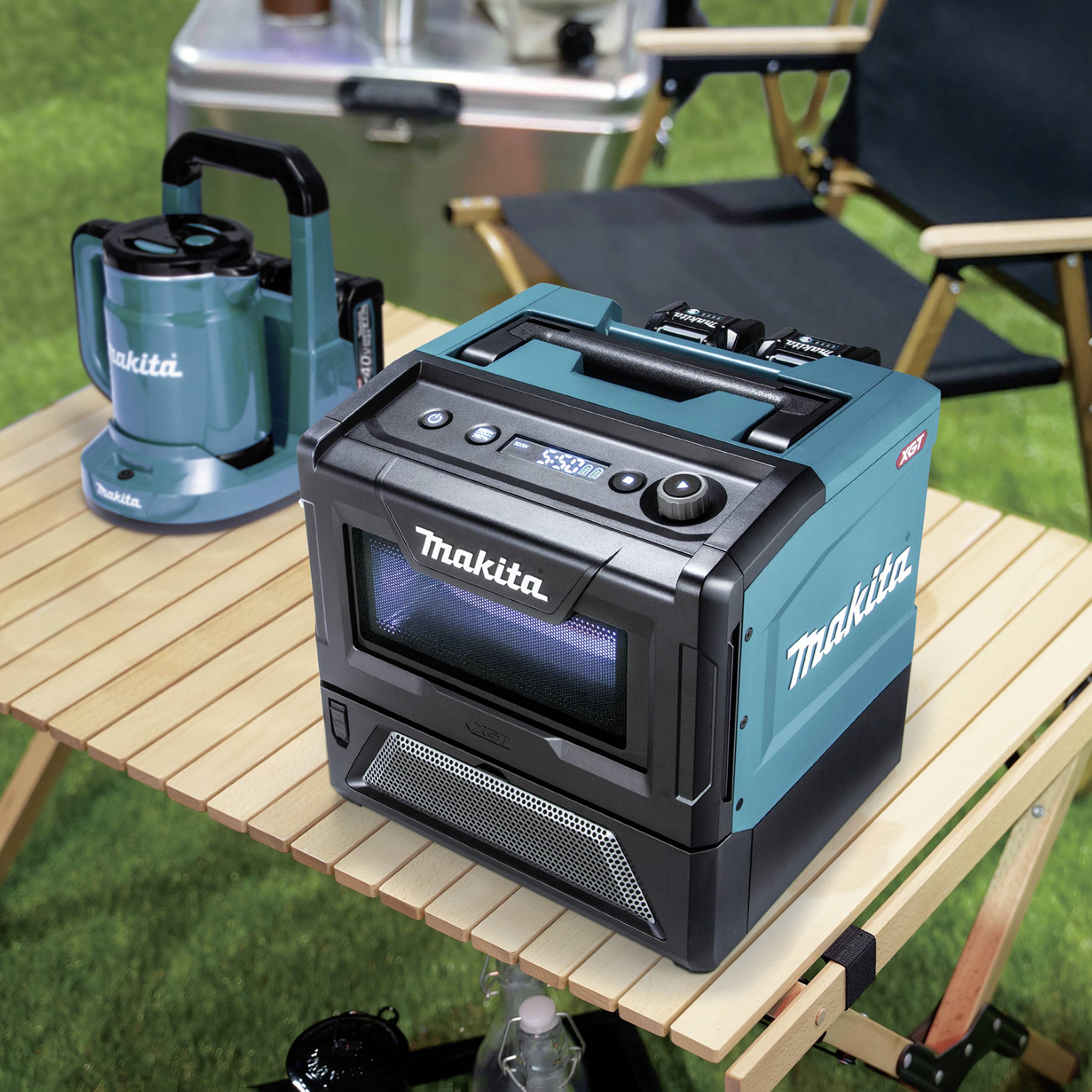 Ein tragbarer, kabelloser Lautsprecher von Makita steht auf einem Campingtisch im Freien. Daneben steht eine Makita-Kaffeemaschine.