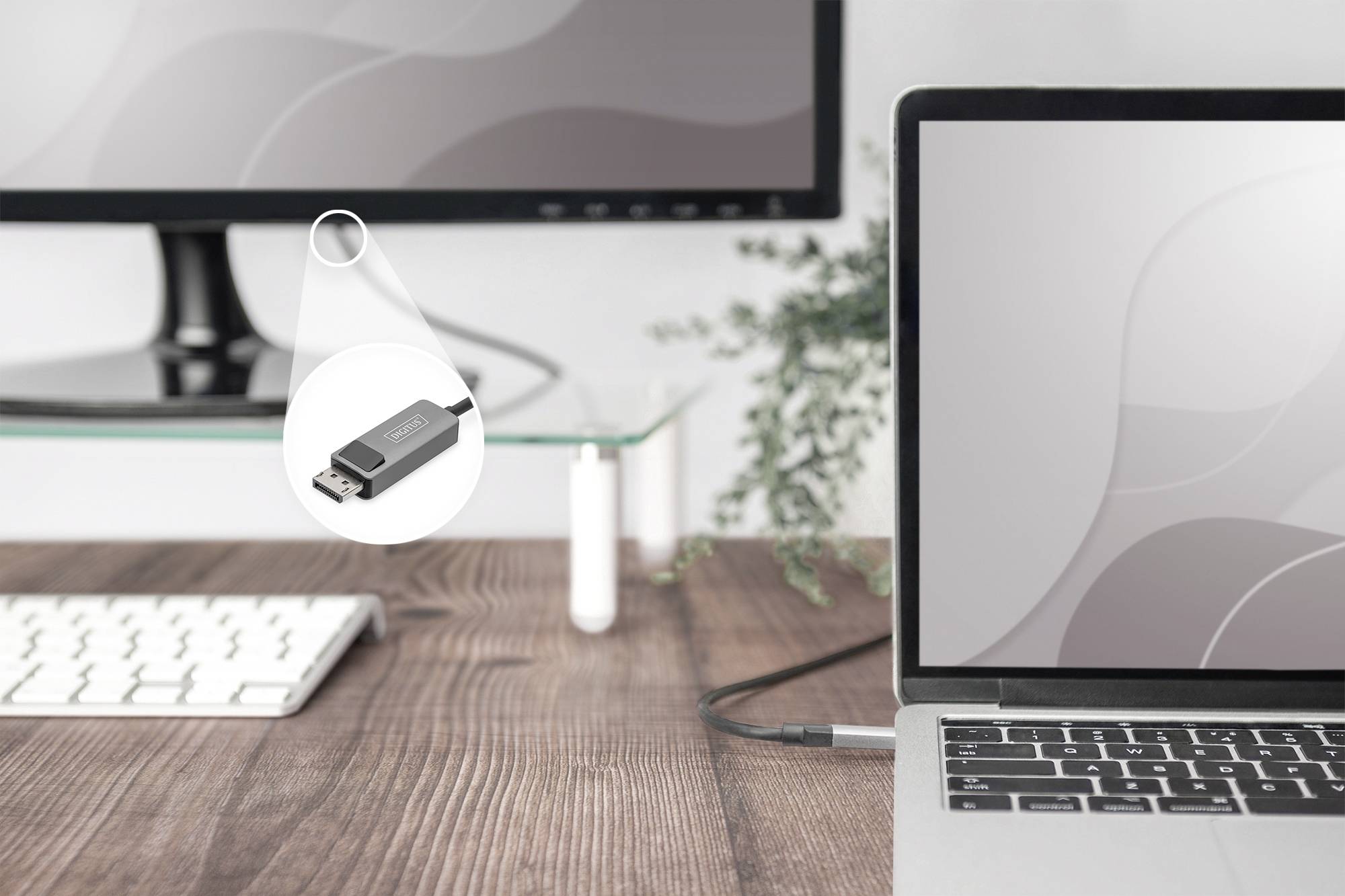 Ein Laptop und ein Monitor sind mit einem USB-C-Adapter verbunden. Der Adapter liegt auf einem Holztisch neben einer Tastatur.