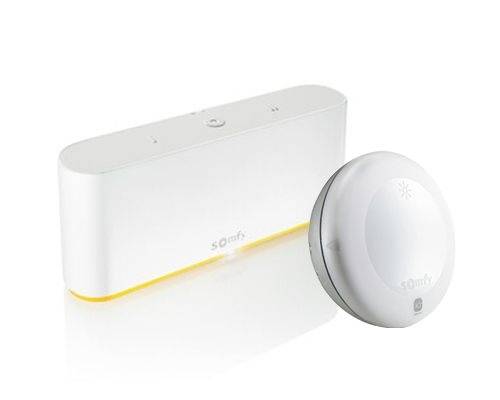 Ein Smart-Home-Gerät mit rechteckigem Sensor vorne und rundem Sensor daneben. Beide sind weiß mit kleinen Markierungen.