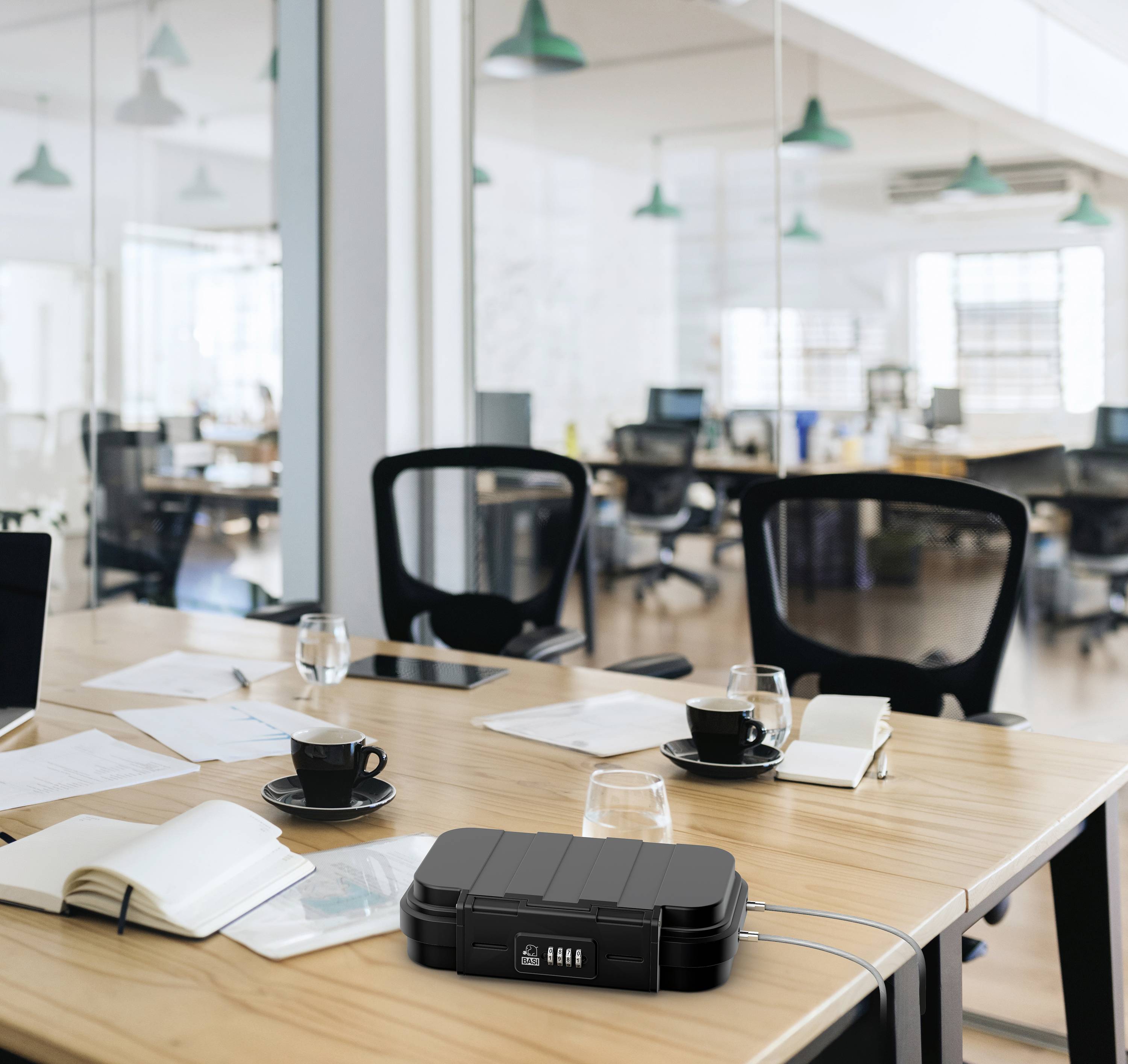 Ein moderner Besprechungsraum mit Tisch, Stühlen und Notizbuch auf dem Tisch. Der Raum ist mit Glaswänden und Pendelleuchten ausgestattet.