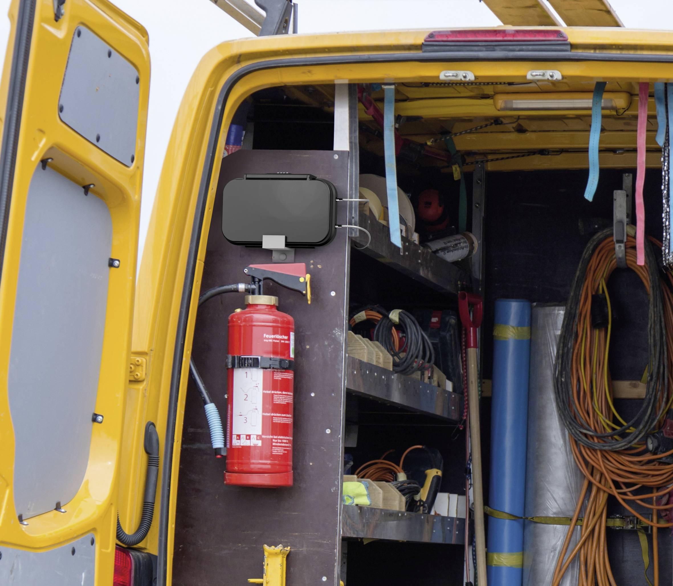 Gelber Transporter mit offener Hecktür zeigt Werkzeuge und Materialien im Inneren. Ein Feuerlöscher ist prominent montiert.