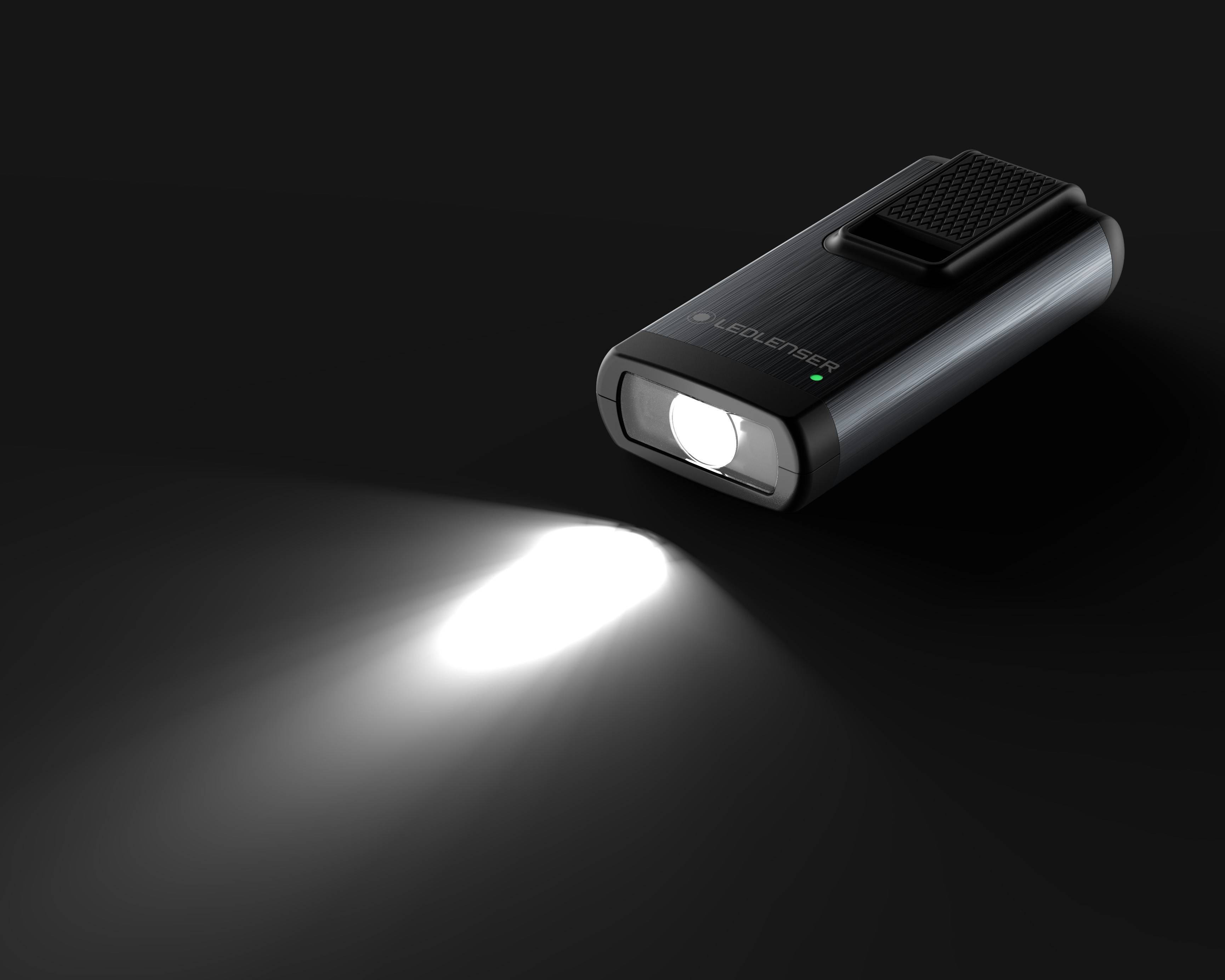 Taschenlampe leuchtet auf dunklem Hintergrund. Sie hat ein kompaktes Design und sendet einen starken Lichtstrahl aus.