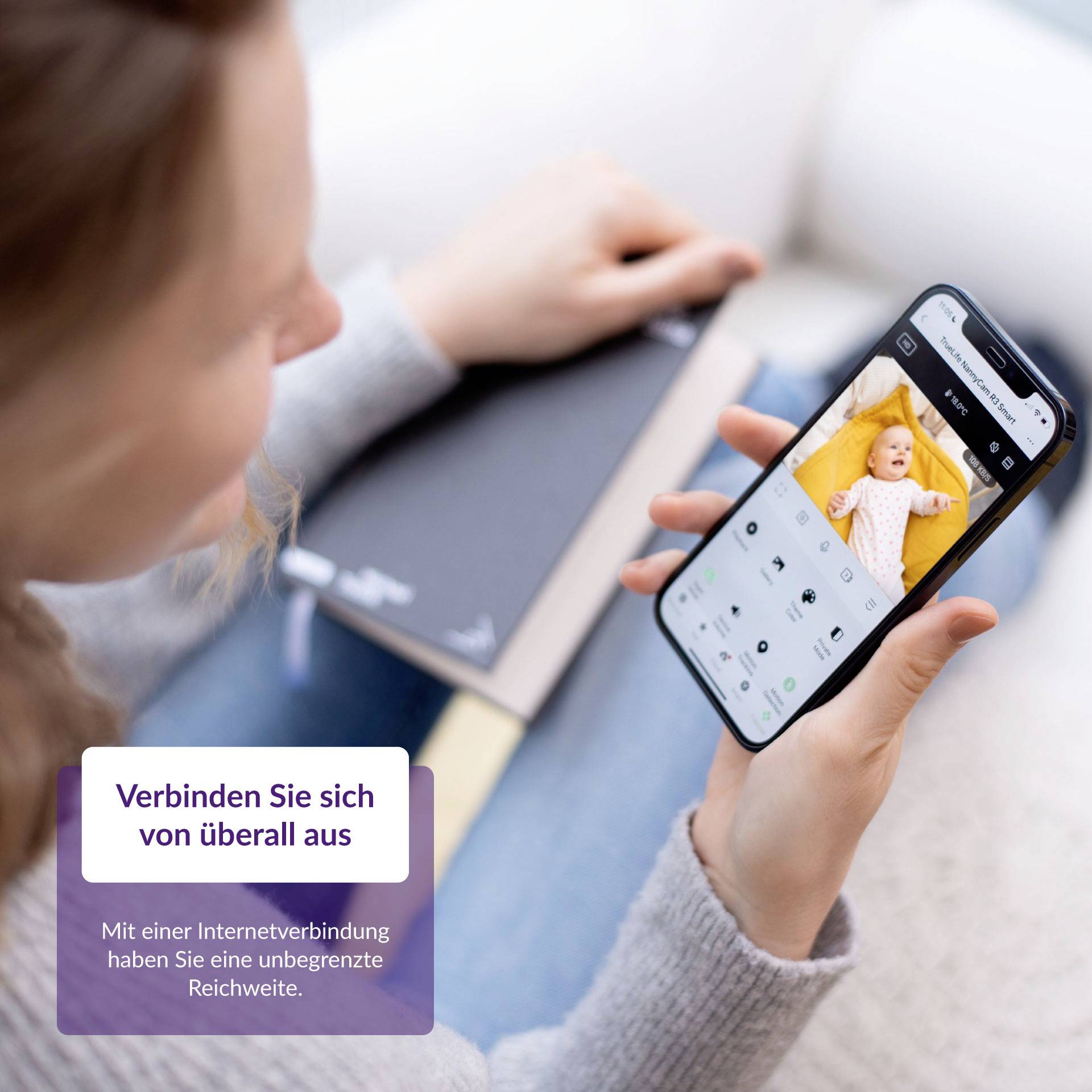 Eine Person hält ein Smartphone mit einem Baby auf dem Bildschirm. Text in der Ecke sagt: 'Verbinden Sie sich von überall aus'.