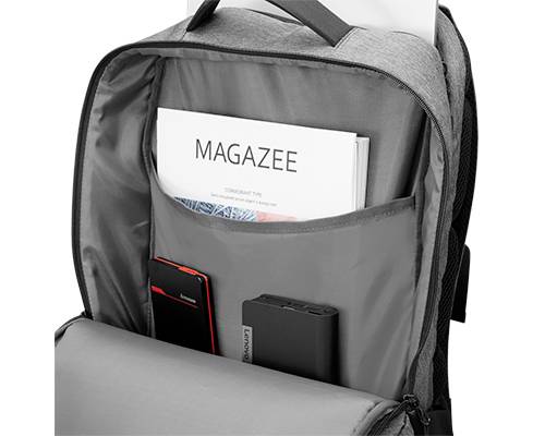 Ein grauer Rucksack mit geöffnetem Hauptfach. Sichtbar sind eine Zeitschrift mit dem Titel 'MAGAZEE' und elektronische Geräte darin.