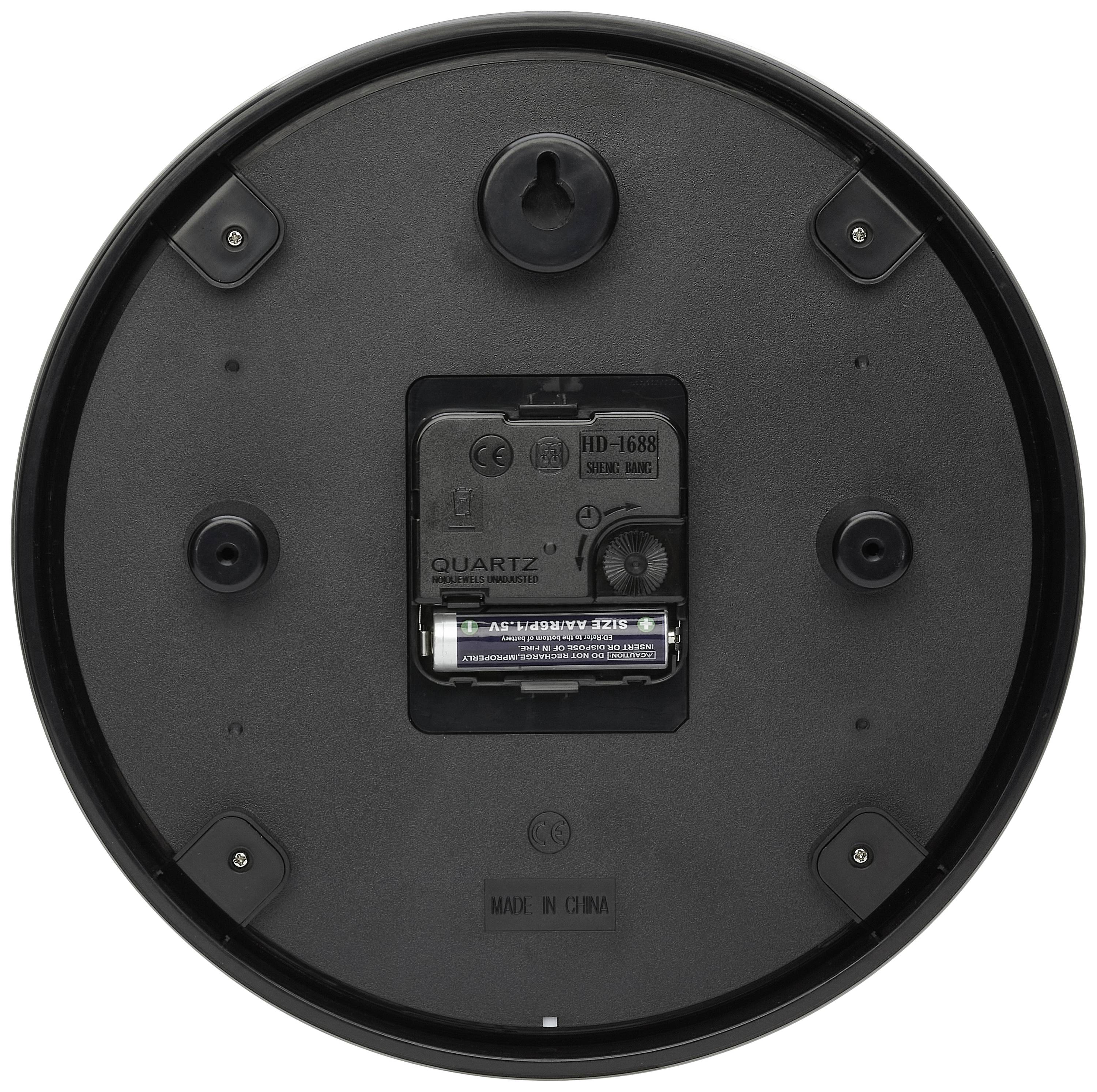 Eine runde, schwarze Rückseite einer Wanduhr mit sichtbarem Batteriefach in der Mitte, umgeben von vier Aufhängepunkten.