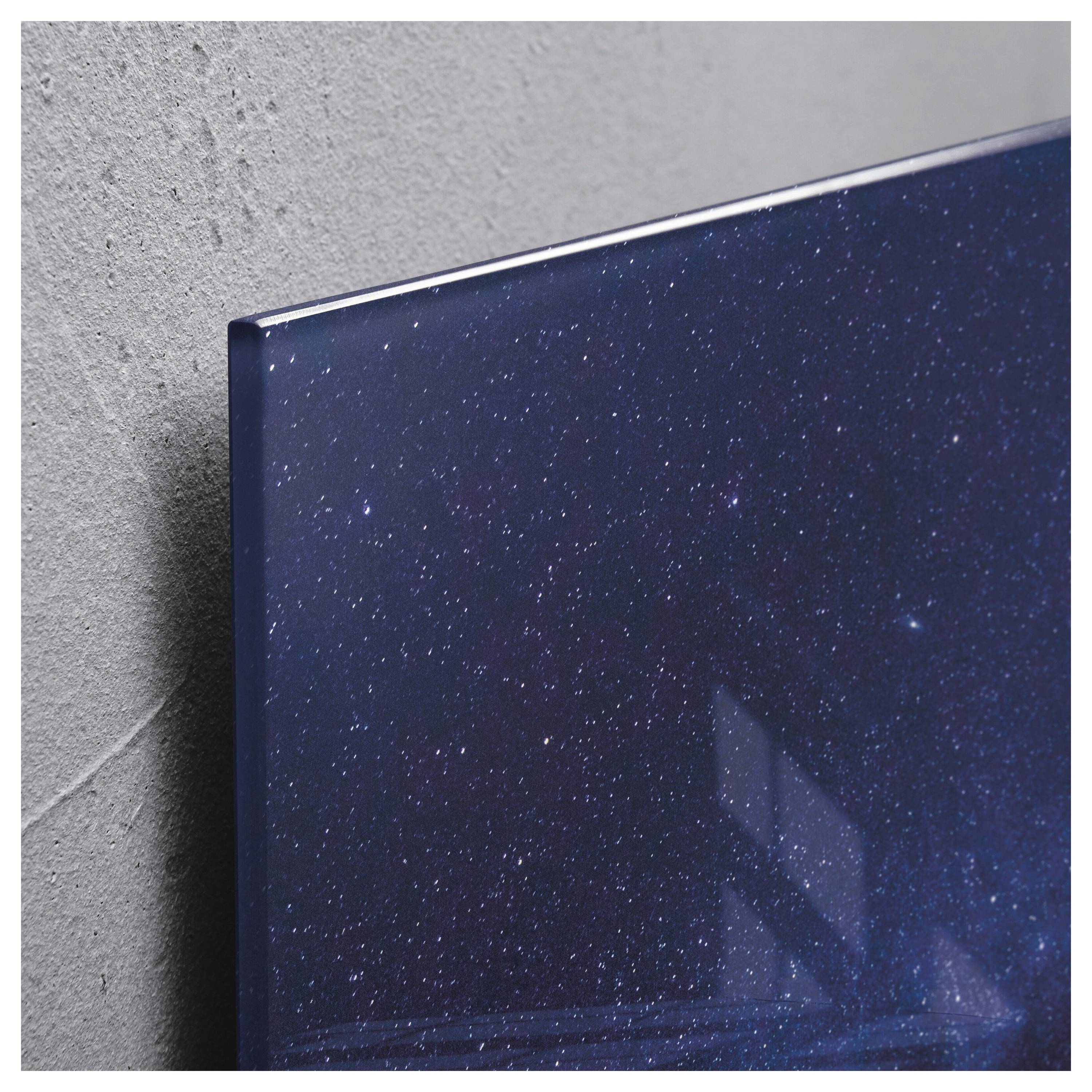 Nahaufnahme eines an der Wand montierten Flachbildfernsehers, der ein Bild eines Sternenhimmels anzeigt, vor einer grau strukturierten Wand.