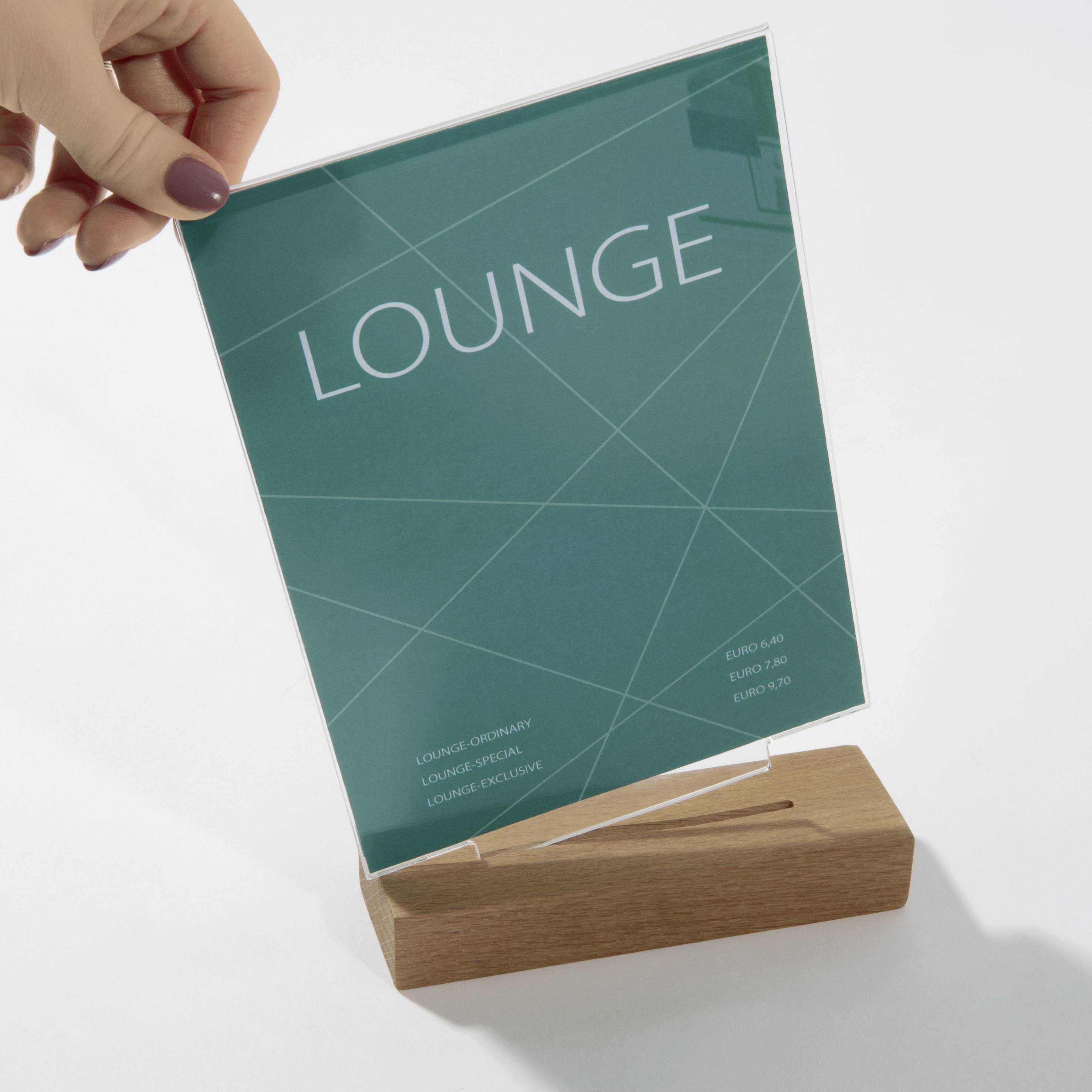 Ein auf einem Holzständer aufgehängter Schild mit der Aufschrift 'LOUNGE' und Preisinformationen für verschiedene Lounge-Angebote.