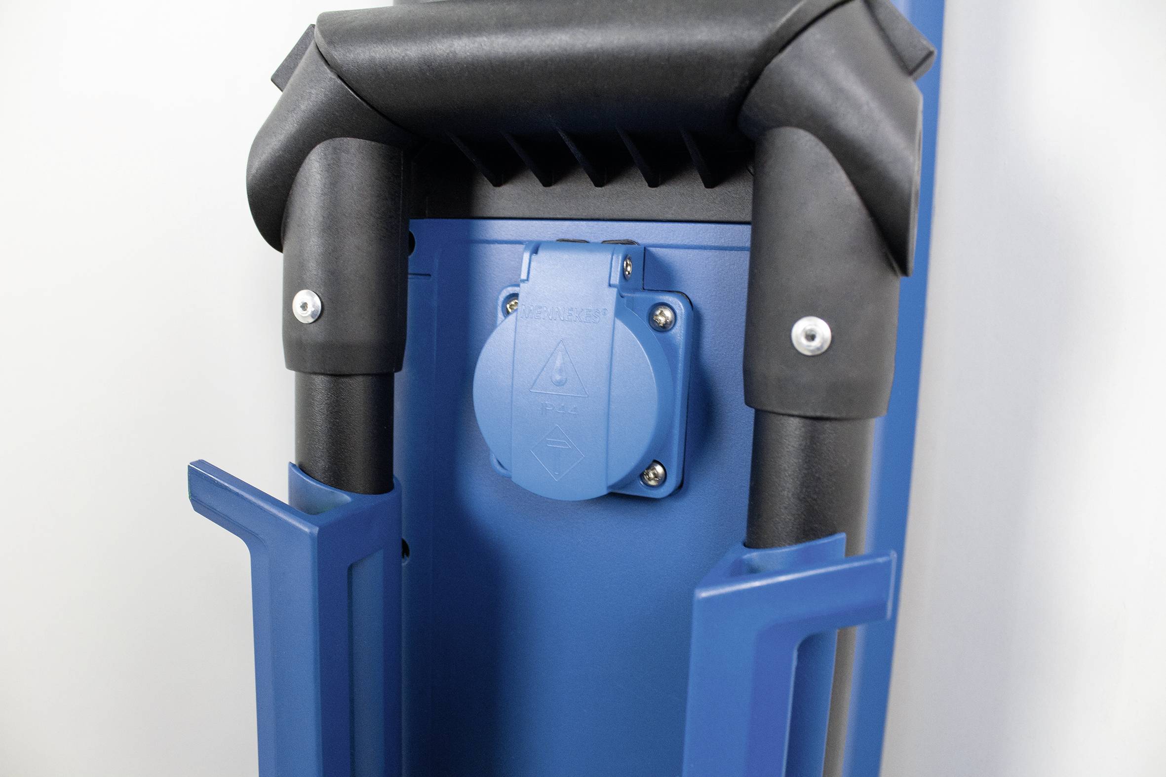 Blauer Rollkoffer mit schwarzem Griff und sichtbarer Steckdose auf der Rückseite, designed für bequemes Reisen.