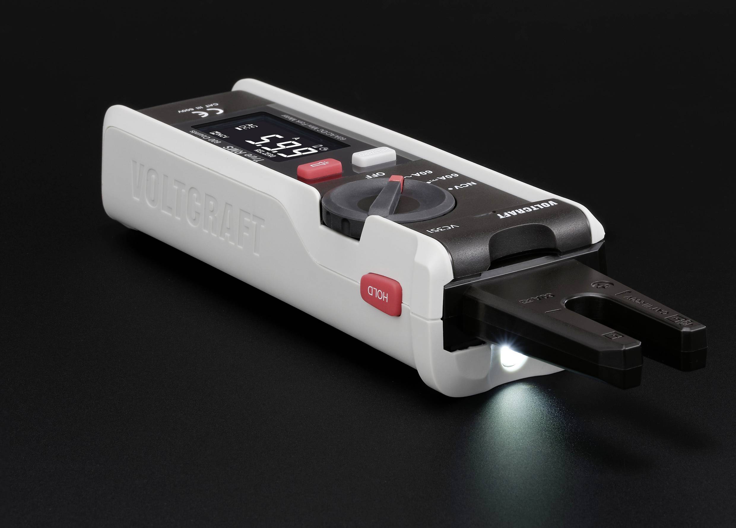 Ein digitaler Spannungsprüfer mit beleuchtetem Display zeigt '5,91 V' an. Das Gerät liegt auf einer dunklen Oberfläche.