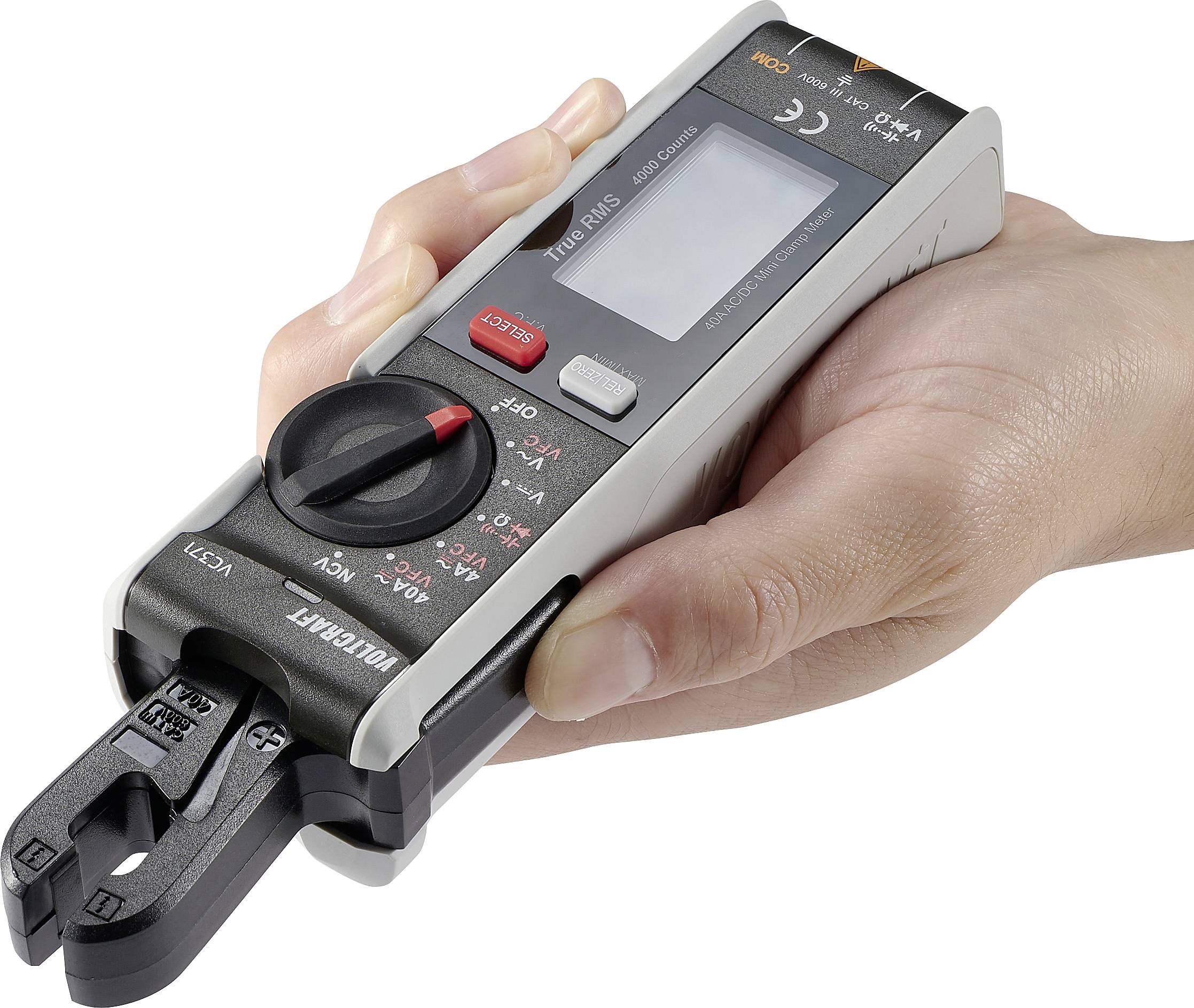 Jemand hält ein tragbares digitales Multimeter mit Display und Drehschalter. Es eignet sich zur Spannungs- und Strommessung.