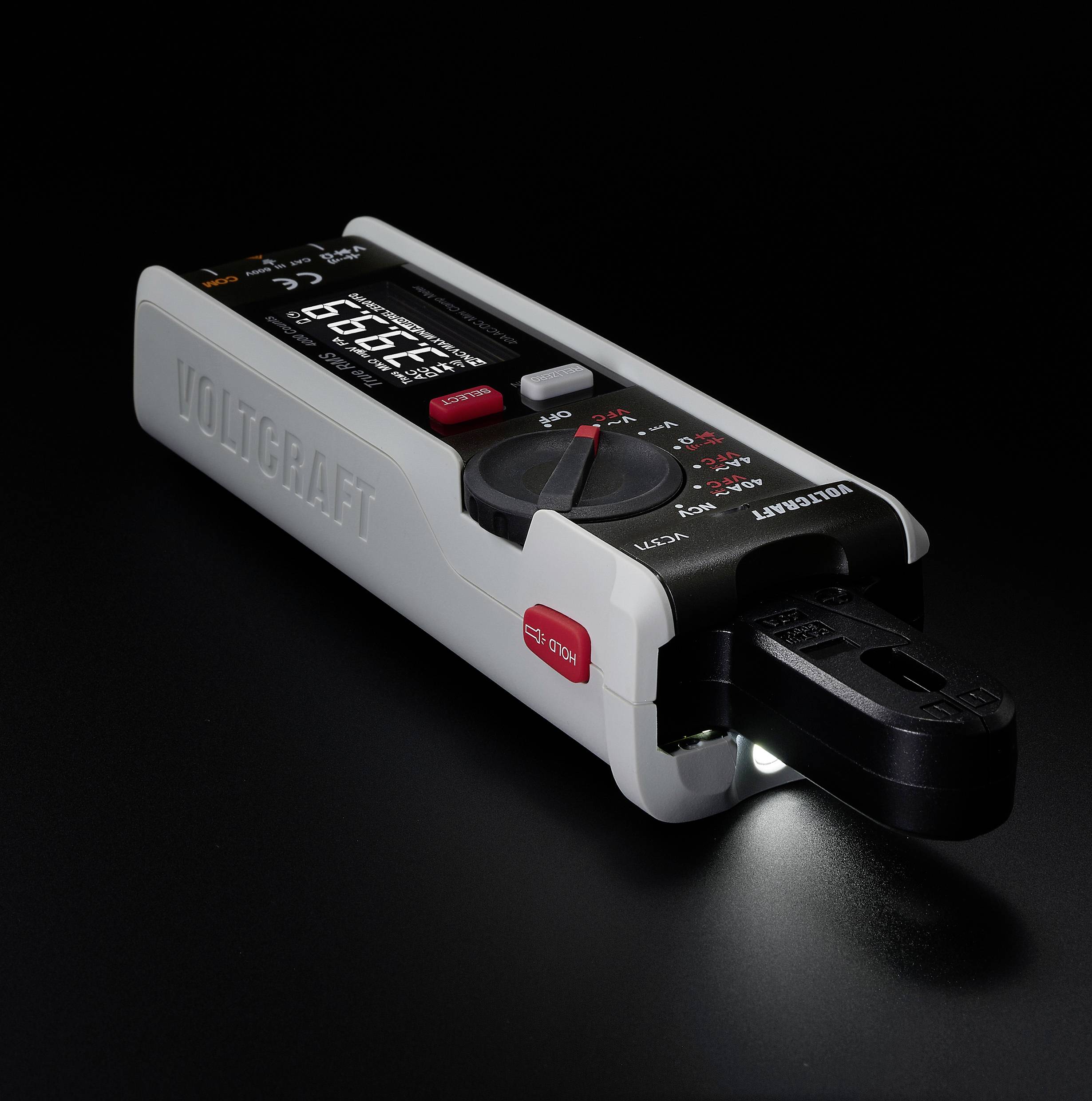 Digitales Multimeter mit beleuchtetem Display auf schwarzem Hintergrund. Gerät zeigt Messwerte und hat eine rote Taste und Drehregler.