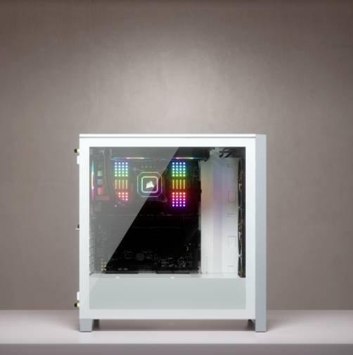 Ein weißer PC mit transparentem Gehäuse zeigt RGB-beleuchtete Komponenten im Inneren, vor einem schlichten, braunen Hintergrund.