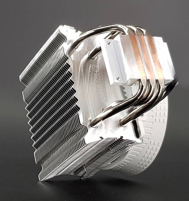 Ein CPU-Kühler mit mehreren Metallrippen und Kupferwärmerohren zur Wärmeabfuhr, vor einem grauen Hintergrund.