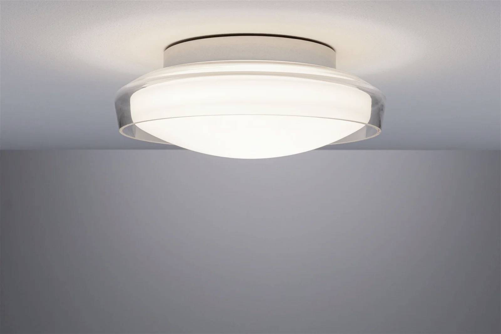 Eine Deckenleuchte mit rundem Glasdesign strahlt warmes Licht aus und sorgt für eine gleichmäßige Beleuchtung des Raumes.
