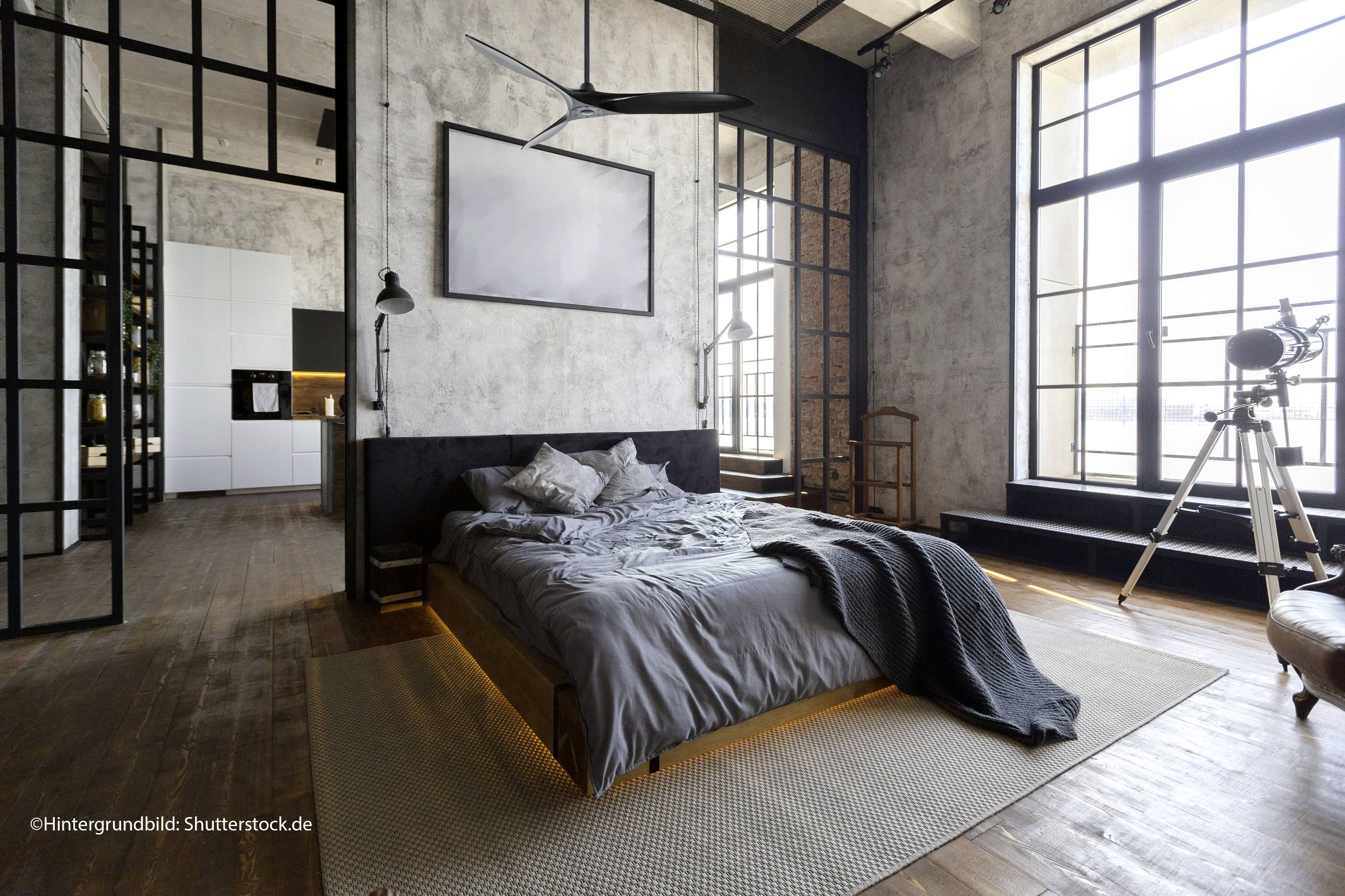 Ein modernes Schlafzimmer mit grauer Bettwäsche, großen Fenstern und einem Teleskop in der Ecke. Ein industrialer Stil dominiert den Raum.