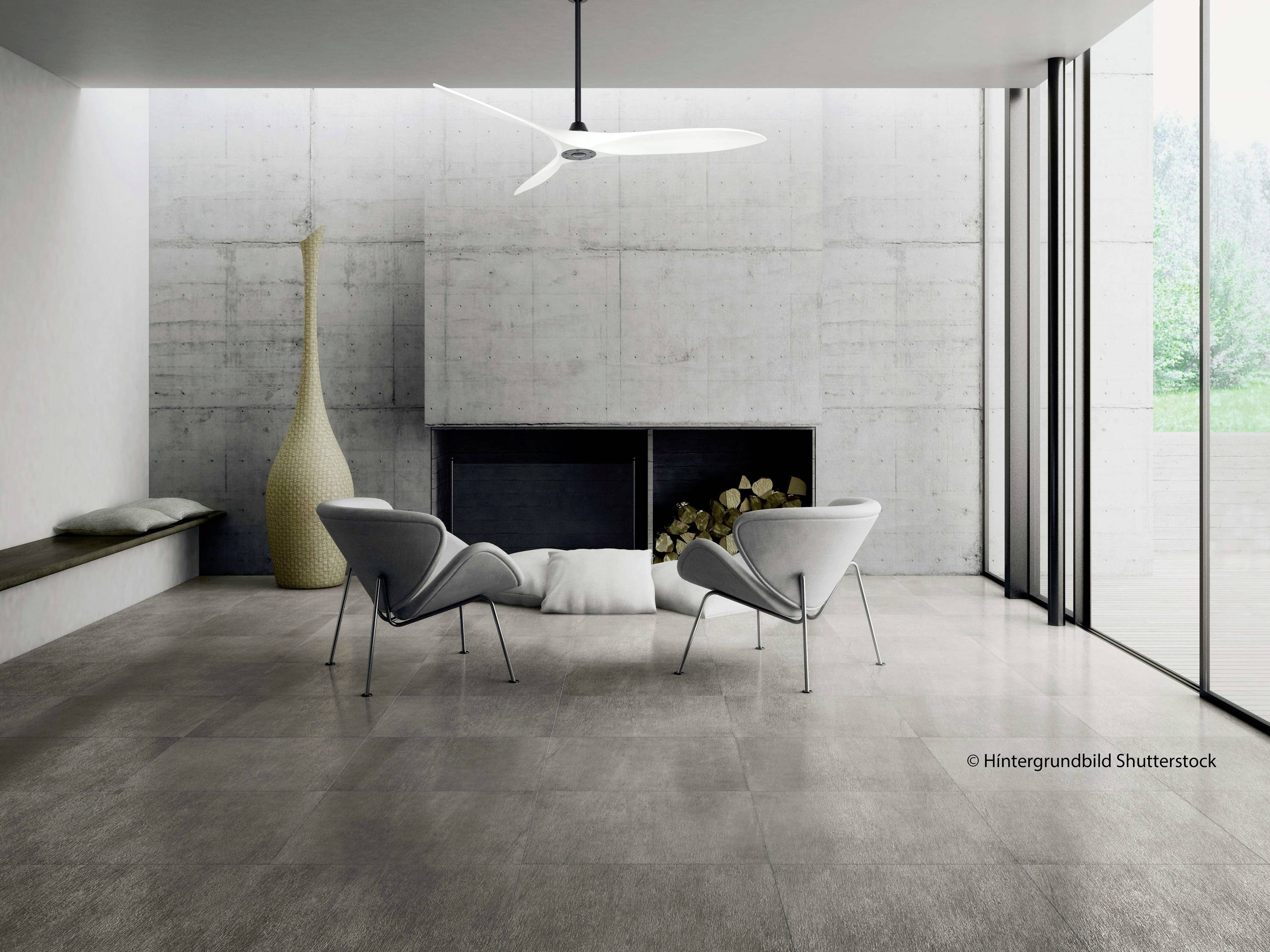 Zwei moderne Stühle vor einem Kamin in einem minimalistischen Wohnzimmer mit großen Fenstern und Betonwänden. Holzscheite sind platziert.