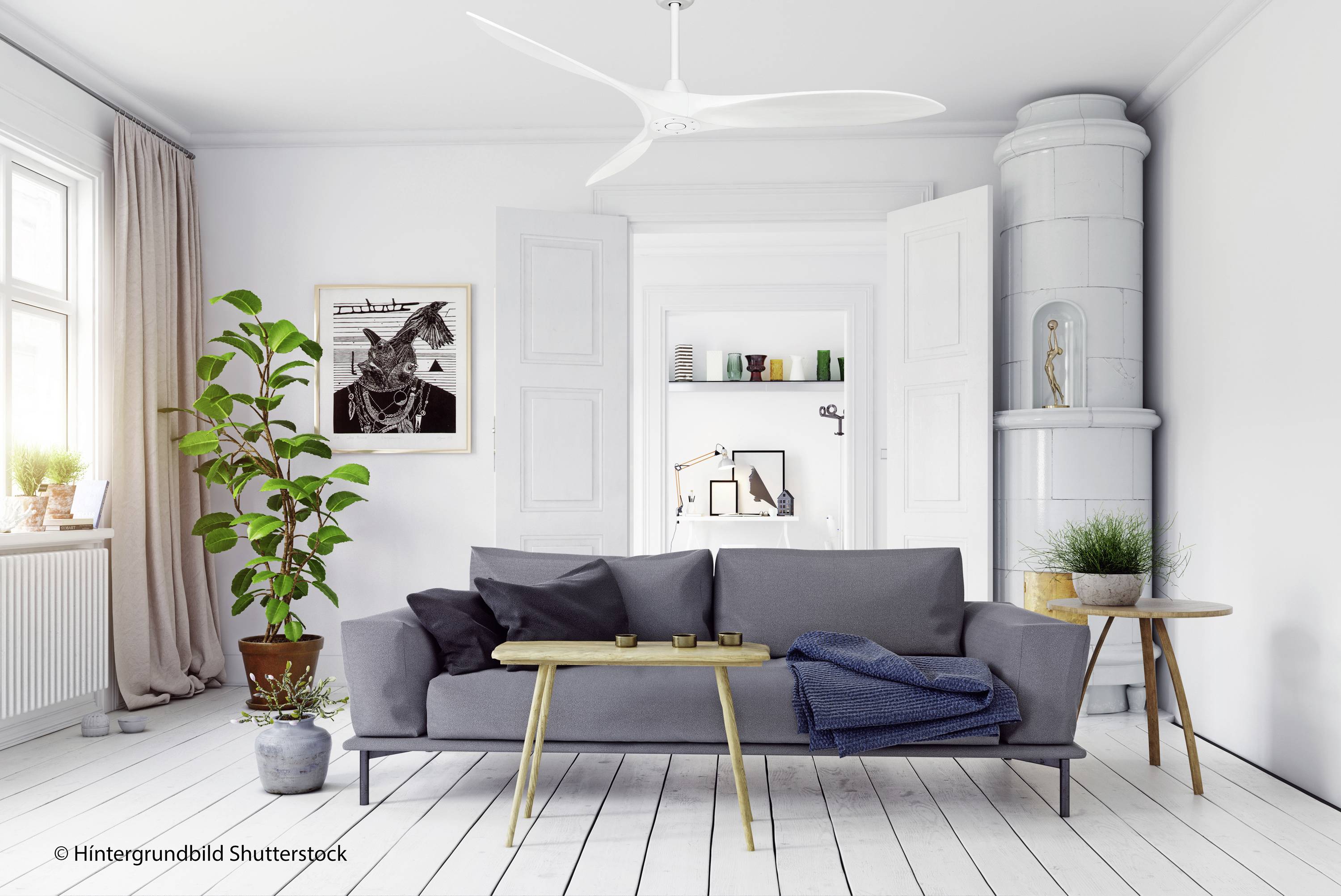 Helles Wohnzimmer mit grauem Sofa, modernem Couchtisch, Pflanzen und Kunstwerk. Weiße Wände, Holzofen und Deckenventilator.